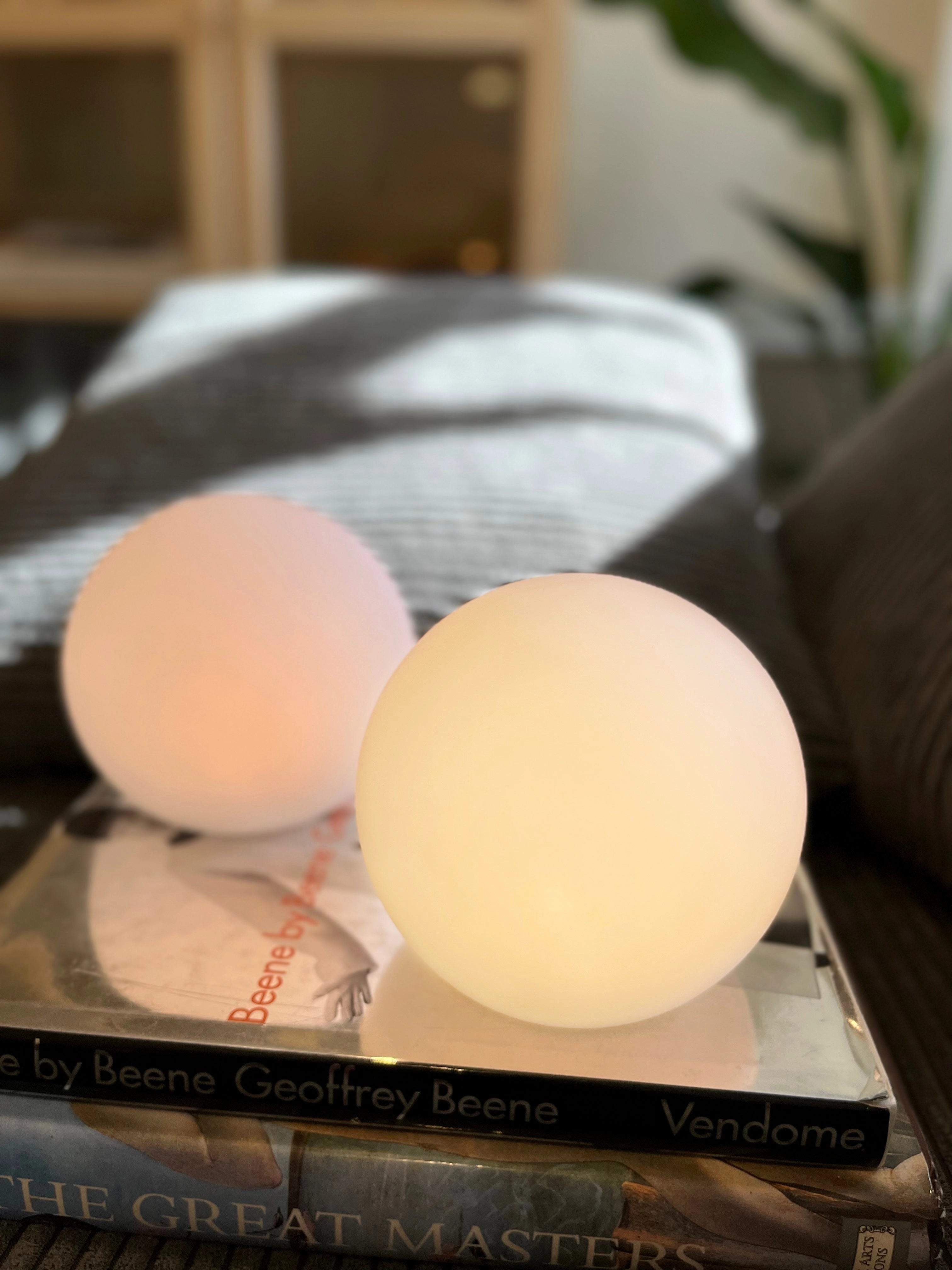 Modern Minimalist LED Globe Lamp on a wooden table with dishware and a small plant nearby.