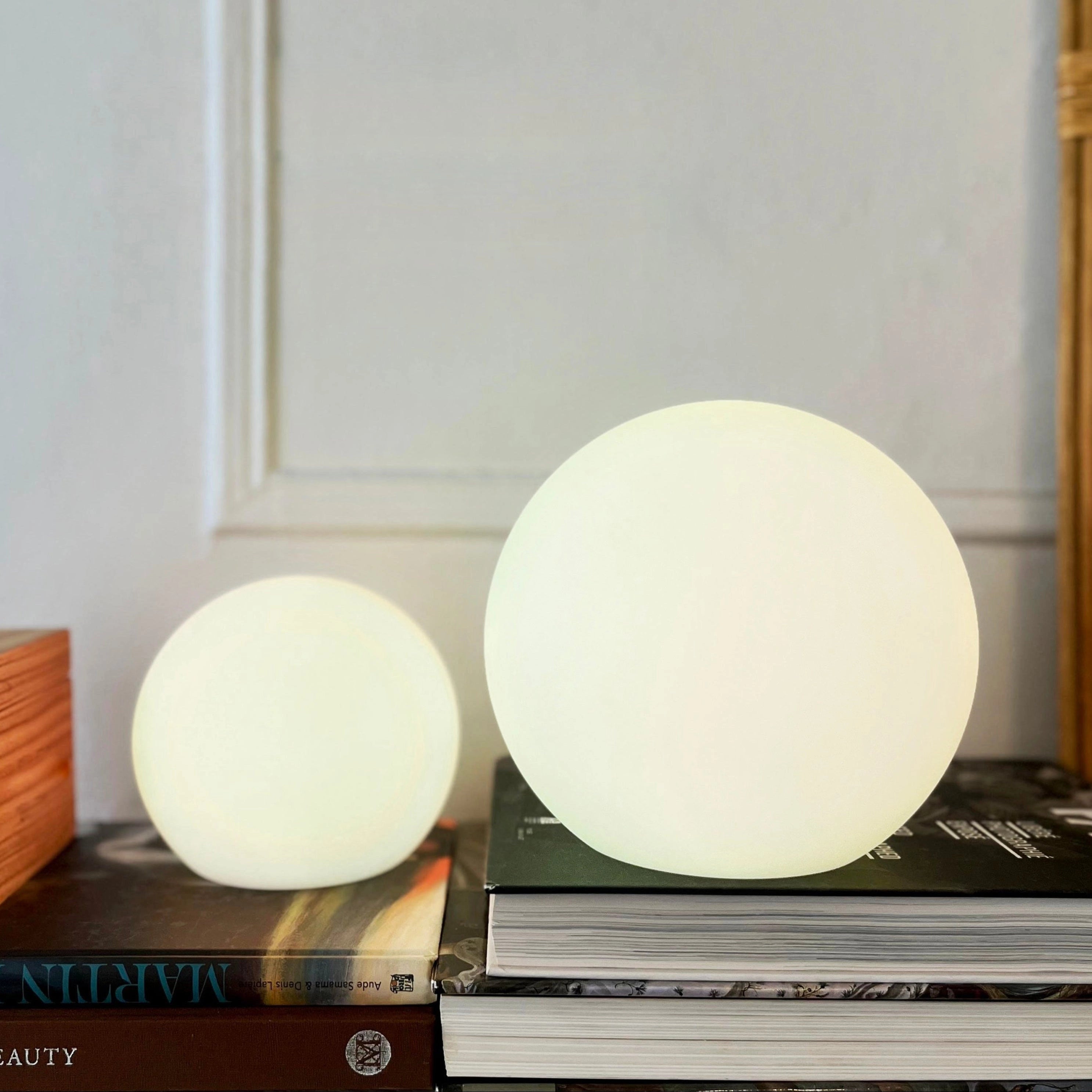 Modern Minimalist LED Globe Lamp - Rechargeable Cordless Bedside Light (6-inch size) placed on a wooden table near shelving units.