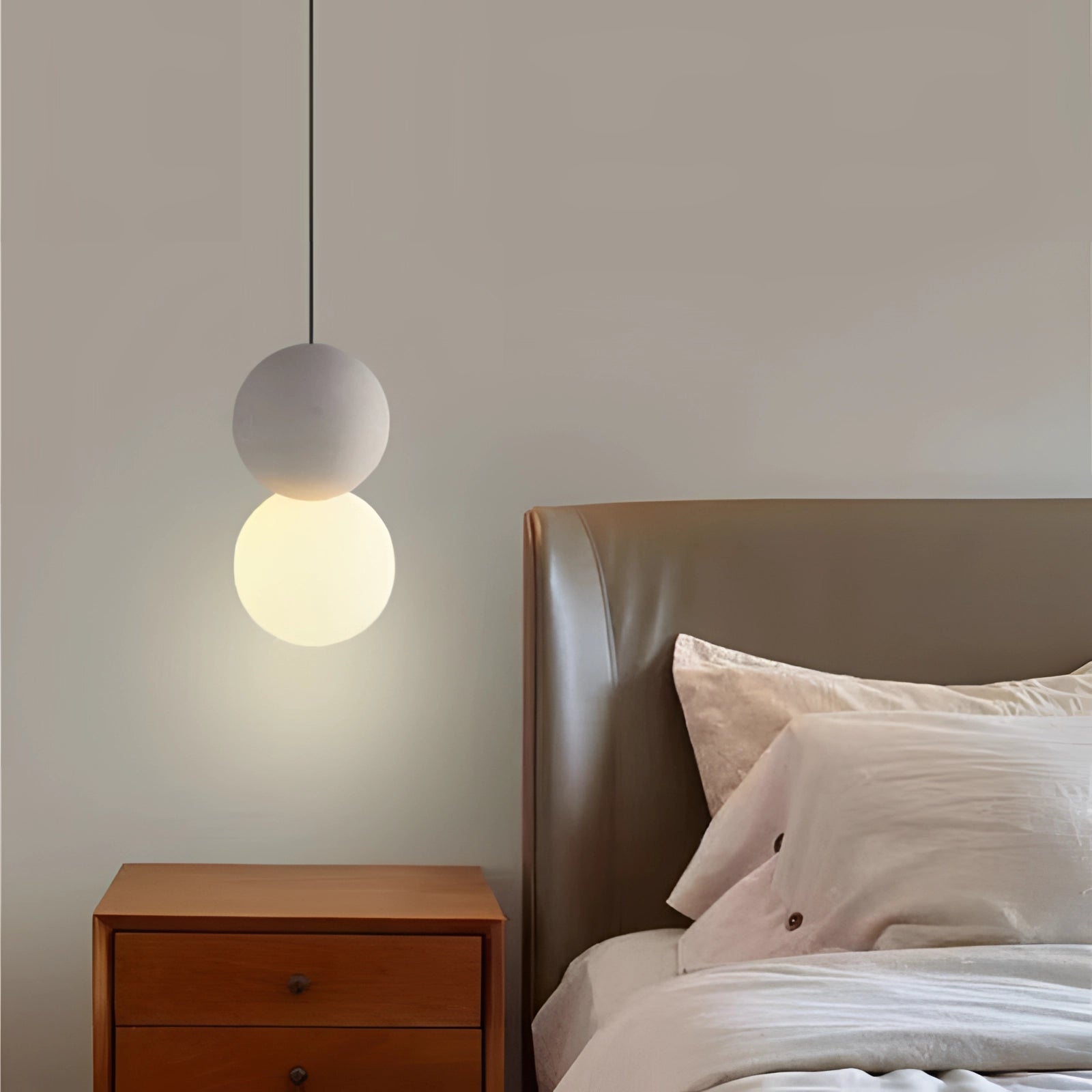 Modern minimalist LED pendant light featuring a sleek black and gray spherical design, illuminated in shades of white and natural white, hanging in a contemporary interior setting.