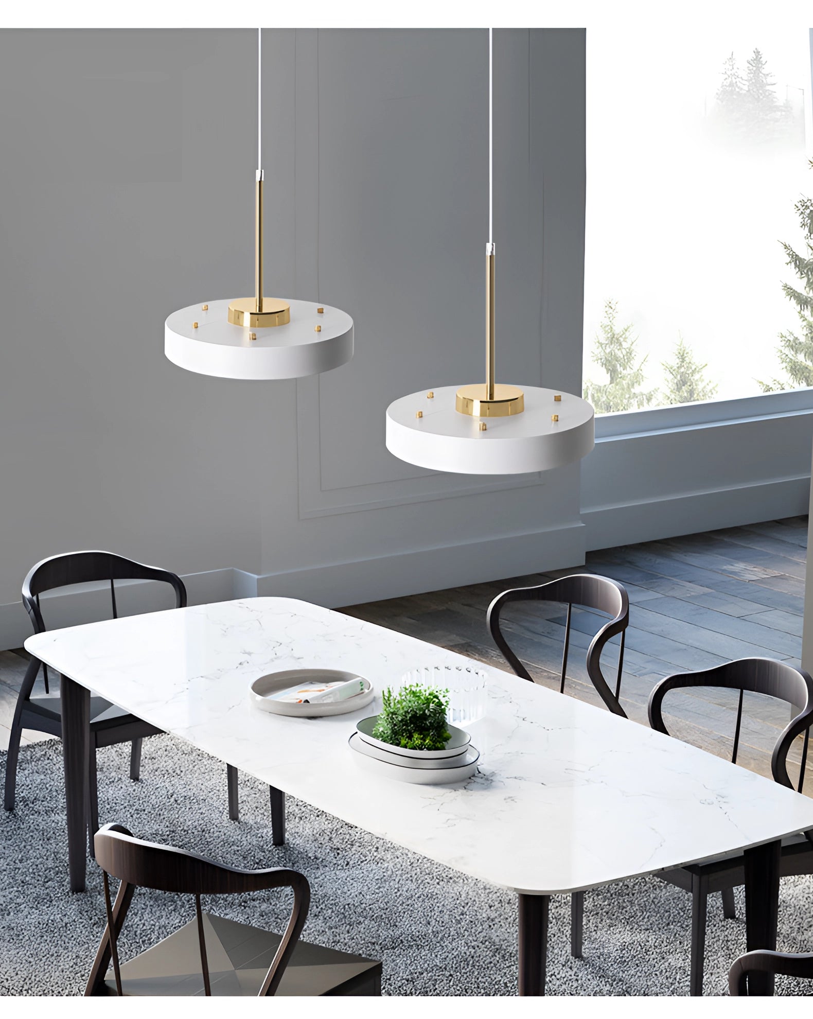Modern minimalist LED pendant lights in gold and white hanging above a stylish wooden table with chairs and a plant.