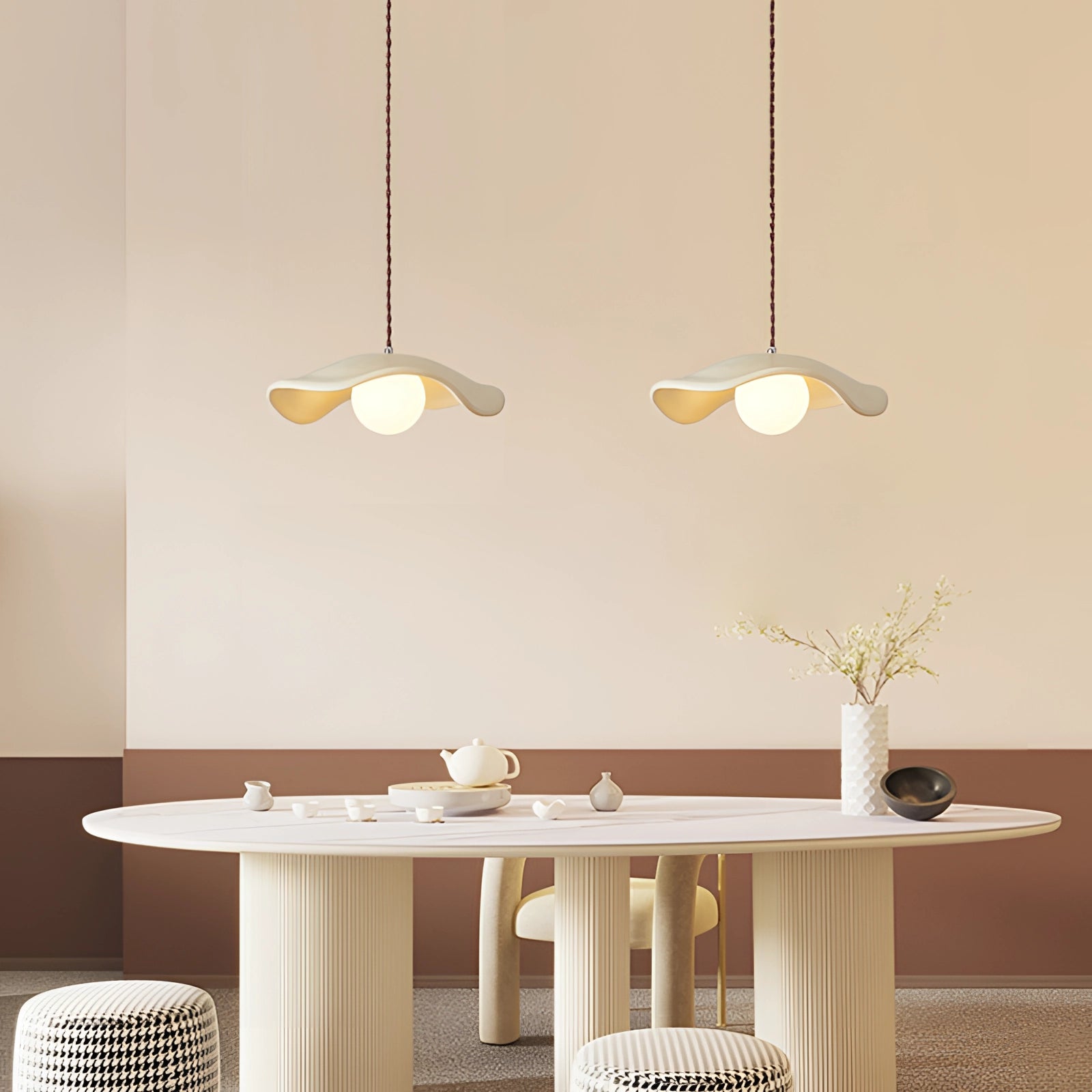 A modern minimalist LED pendant light with dual-sphere design hanging above a wooden table, featuring a sleek white finish, and providing focused lighting in a contemporary setting.