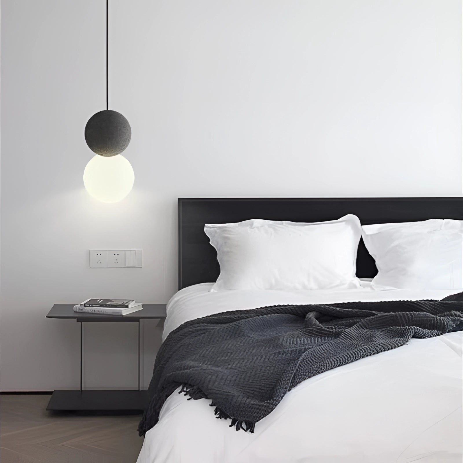 Modern minimalist LED pendant light in black and gray with a spherical design, hanging above a contemporary setting featuring neutral tones and a comfortable ambiance.