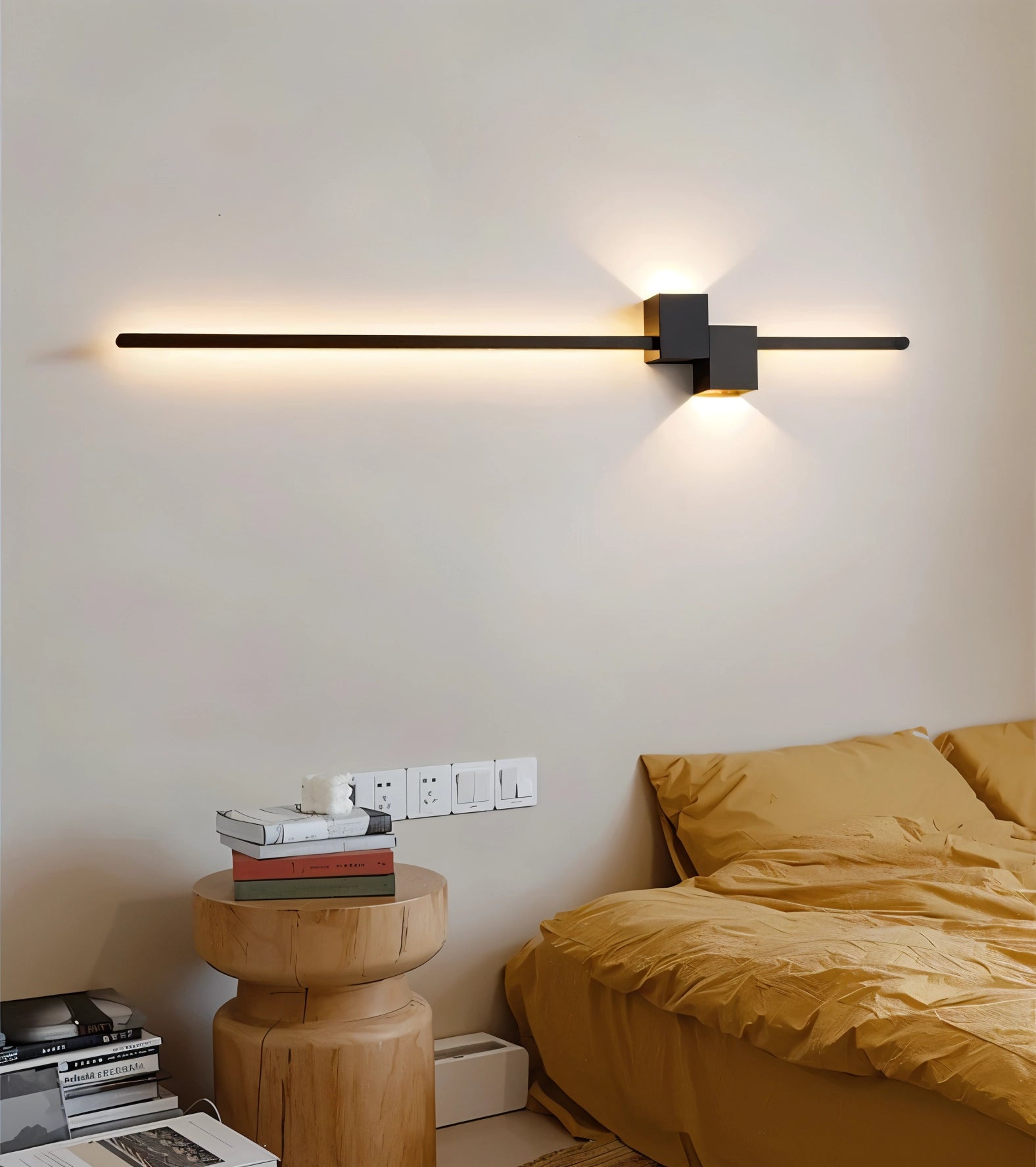 Modern minimalist LED wall light with a sleek beige finish, mounted on a wooden wall, emitting a warm and comfortable glow in a contemporary bedroom setting.