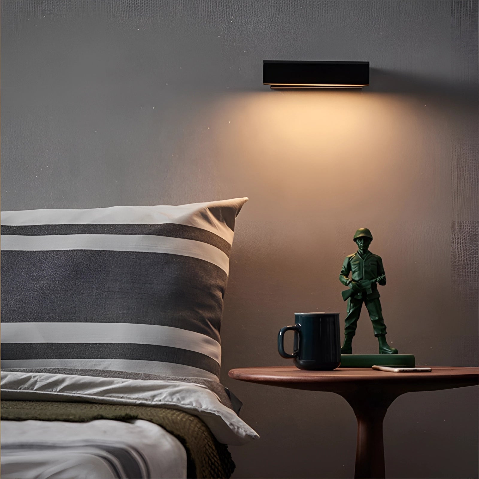 Modern minimalist LED wall sconce with a sleek angular design, mounted on a grey wall, featuring lines and shades that complement the surrounding wooden flooring and contemporary decor.