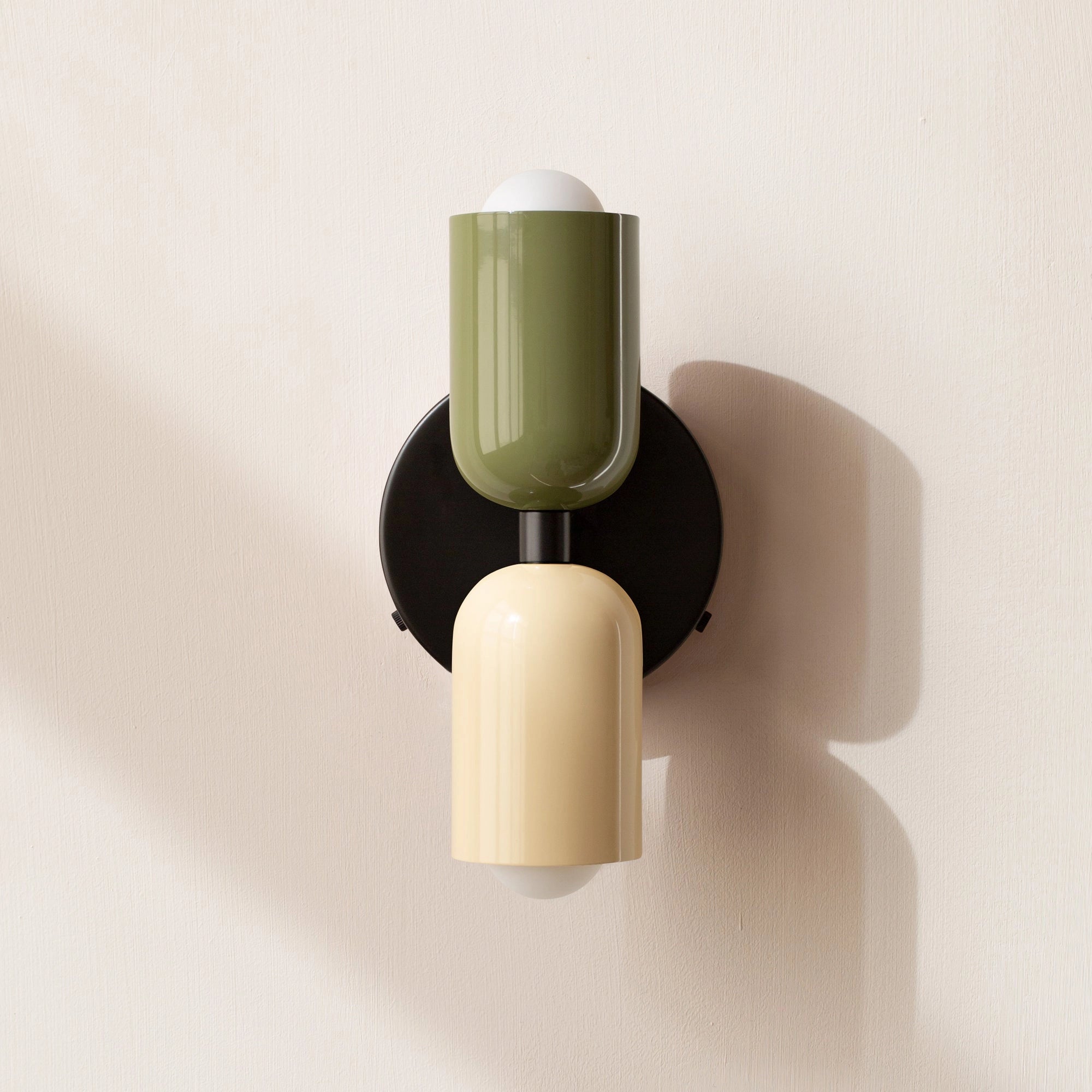 Modern minimalist LED wall sconce with a geometric dual head design, featuring a combination of green, white, and black colors.