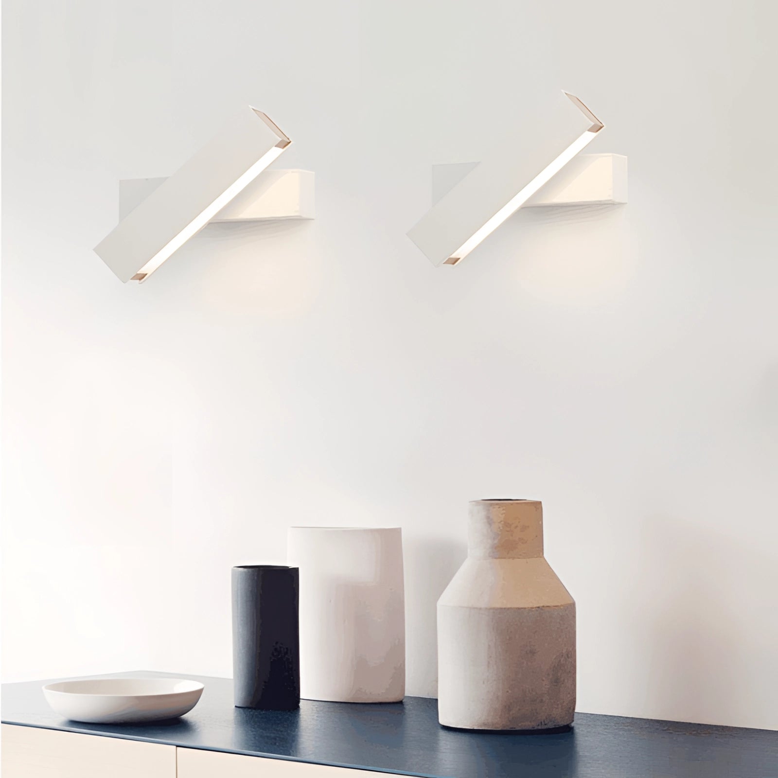 Modern minimalist LED wall sconce with a sleek angular design, featuring a white rectangular fixture mounted on a wooden panel, providing ambient lighting for contemporary interiors.