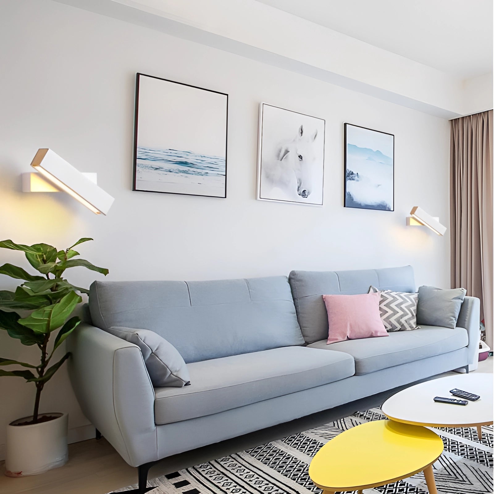 Modern minimalist LED wall sconce with a sleek angular design, mounted on a wall in a contemporary living room setting. The room features a rectangular picture frame, a couch, and a touch of greenery, all contributing to a sophisticated interior design aesthetic.