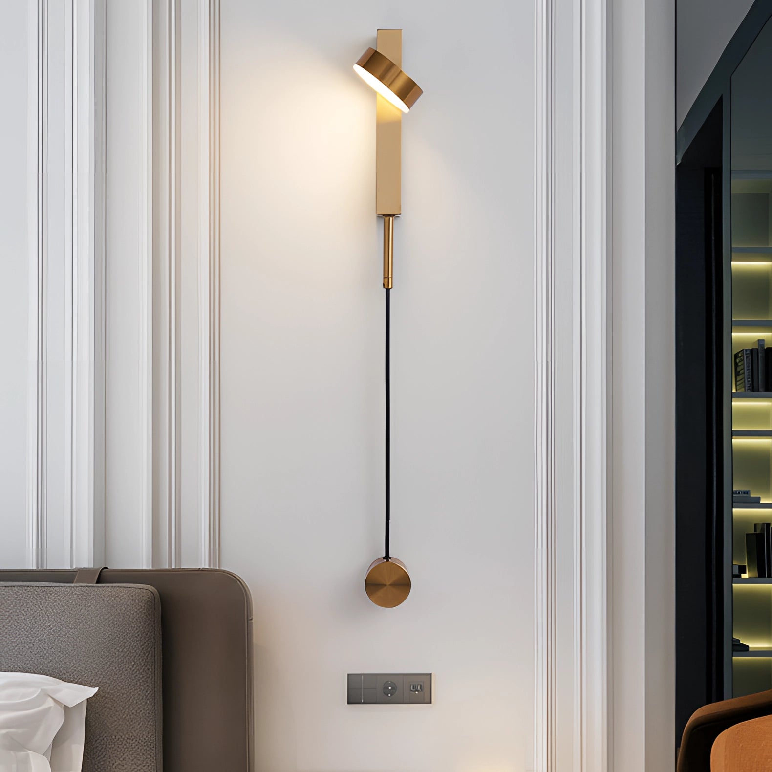 Modern minimalist LED wall sconce with a gold finish, featuring a rectangular design. The fixture is mounted on a wall, providing warm light (3000K), suitable for USA/Canada voltage (110 V-120 V). Ideal for bedroom or living room interior design.