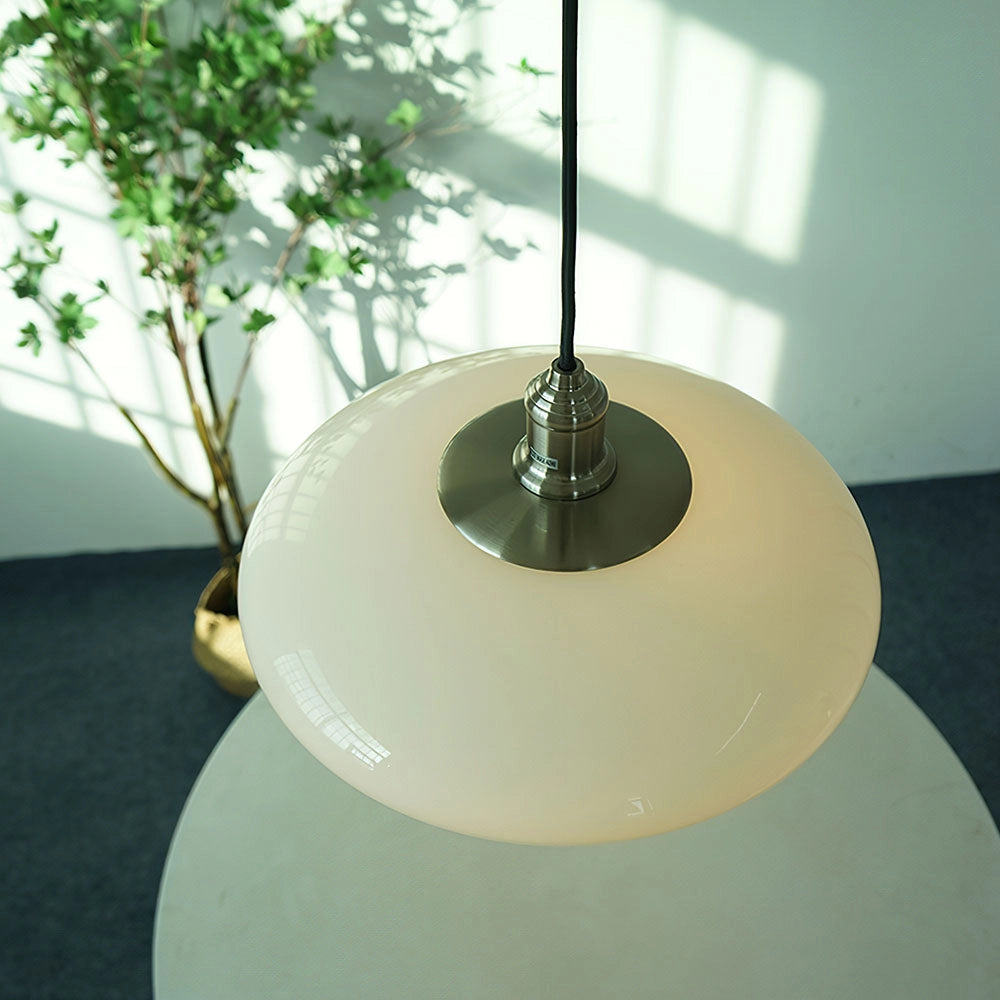 Modern minimalist pendant light with frosted glass shade and adjustable height, featuring a sleek circular design, hanging from a ceiling fixture, providing a soft, diffused glow suitable for contemporary interiors.