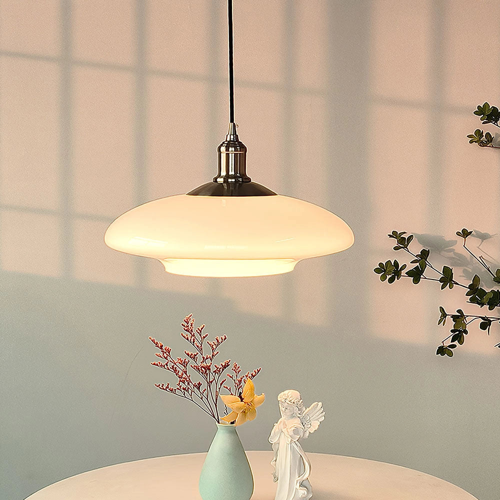 Modern minimalist pendant light with frosted glass shade, featuring adjustable height, hanging in an elegantly designed interior space with natural materials and wooden elements.