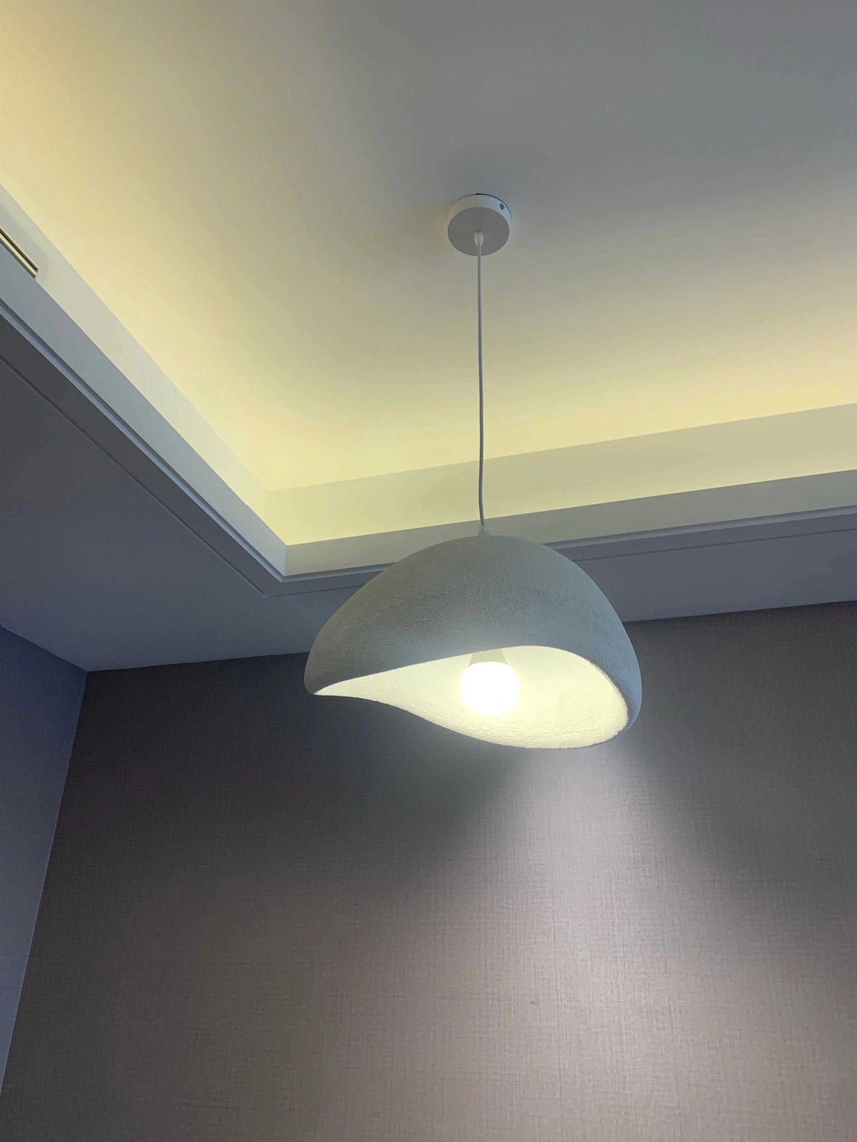 Modern minimalist pendant lights with a Scandinavian design, featuring wooden elements and sleek shades, suspended from the ceiling, illuminating the kitchen space.