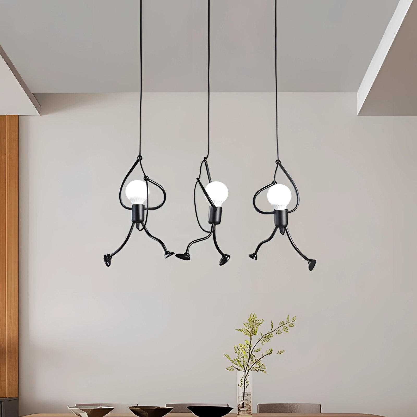 Modern minimalist pendant light chandelier with sculptural design featuring wood and twig-like elements, hanging from the ceiling.