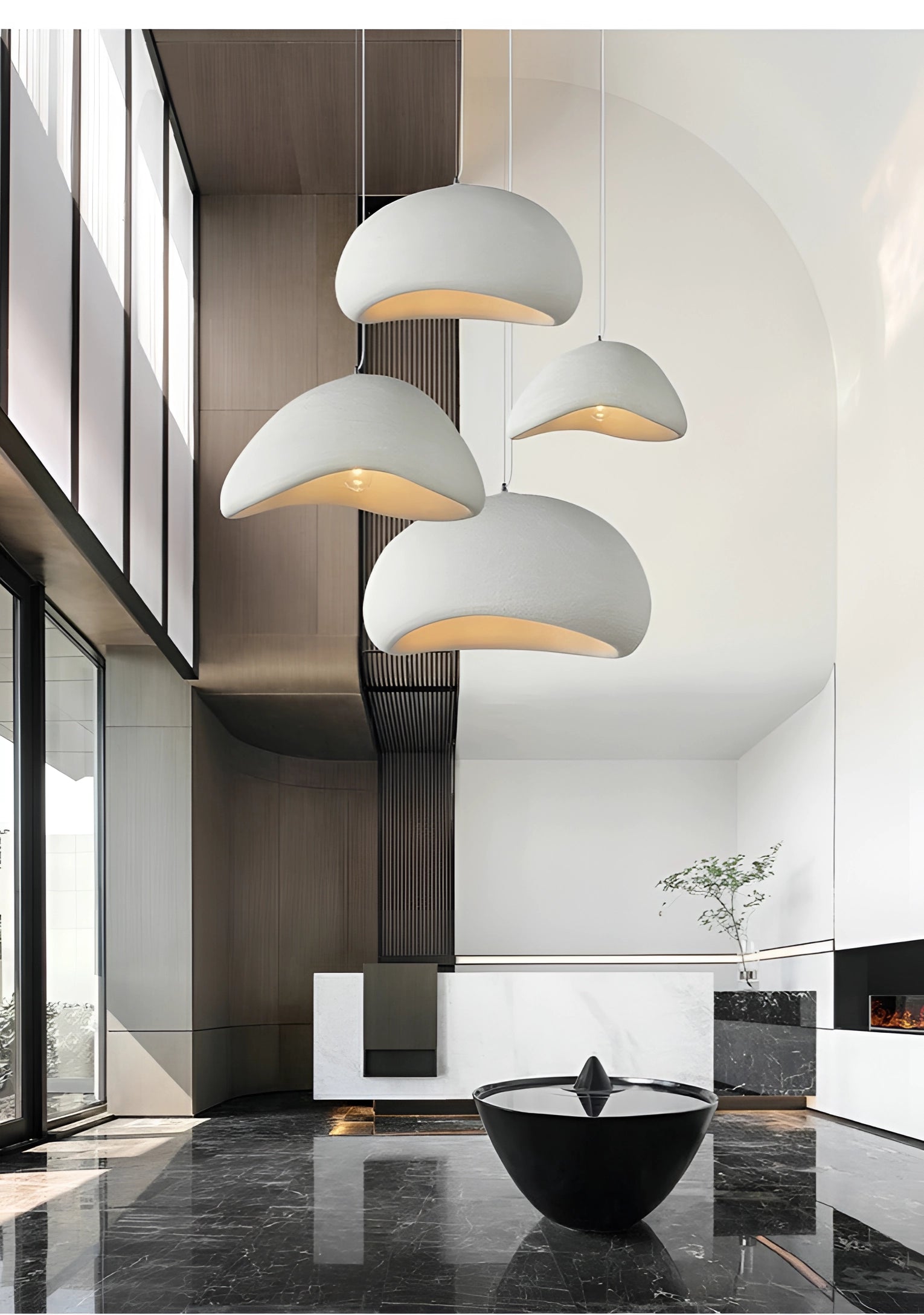 Modern minimalist pendant lights with a Scandinavian design style hanging in a contemporary kitchen setting, featuring sleek interior design elements such as neutral flooring, simple architectural lines, and a touch of greenery.
