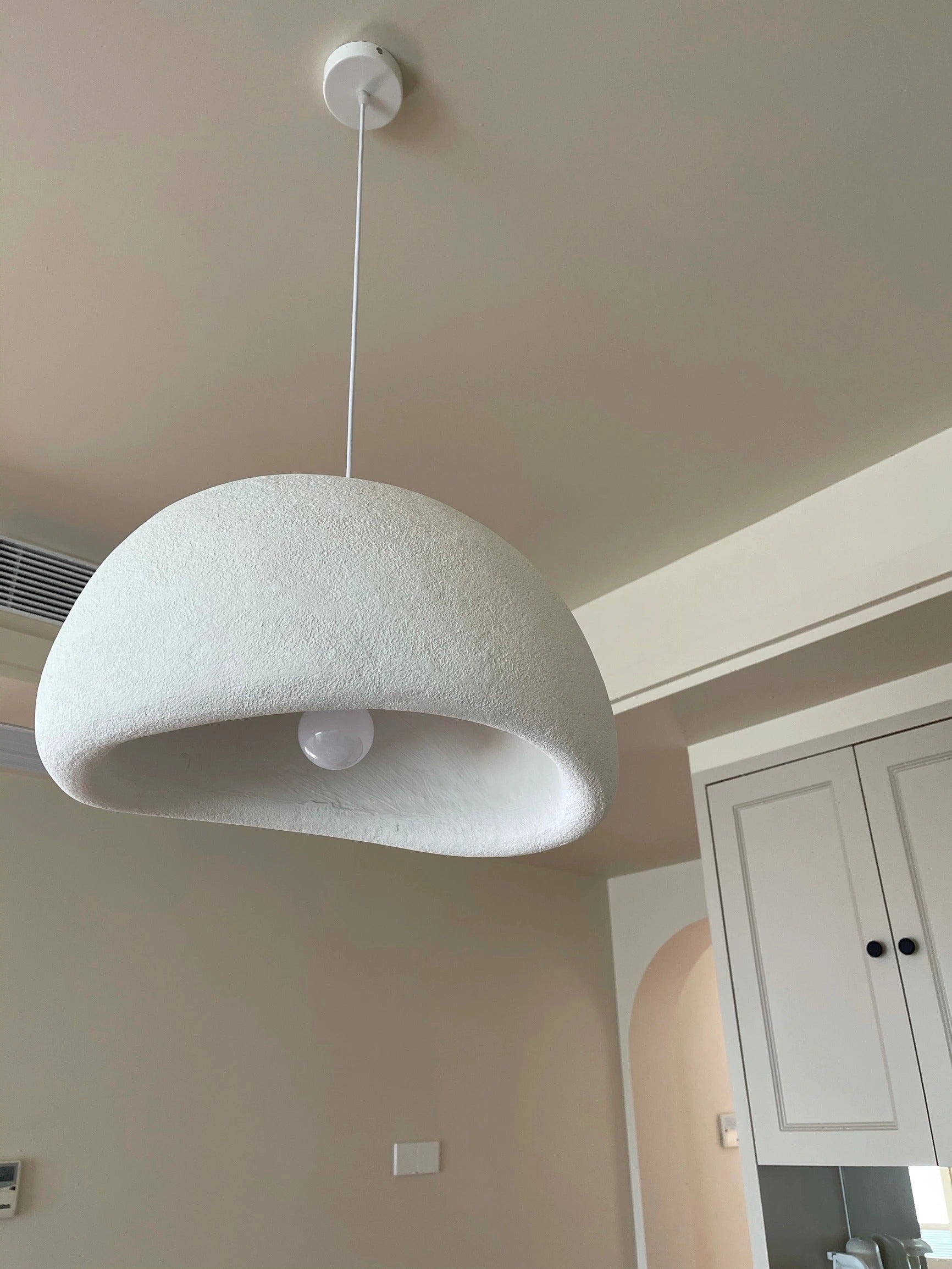 Modern minimalist pendant light with a wooden fixture and shade, designed for Scandinavian kitchen lighting. The light hangs from the ceiling, showcasing its sleek and simple aesthetic, complemented by natural wood elements that enhance the overall ambiance.