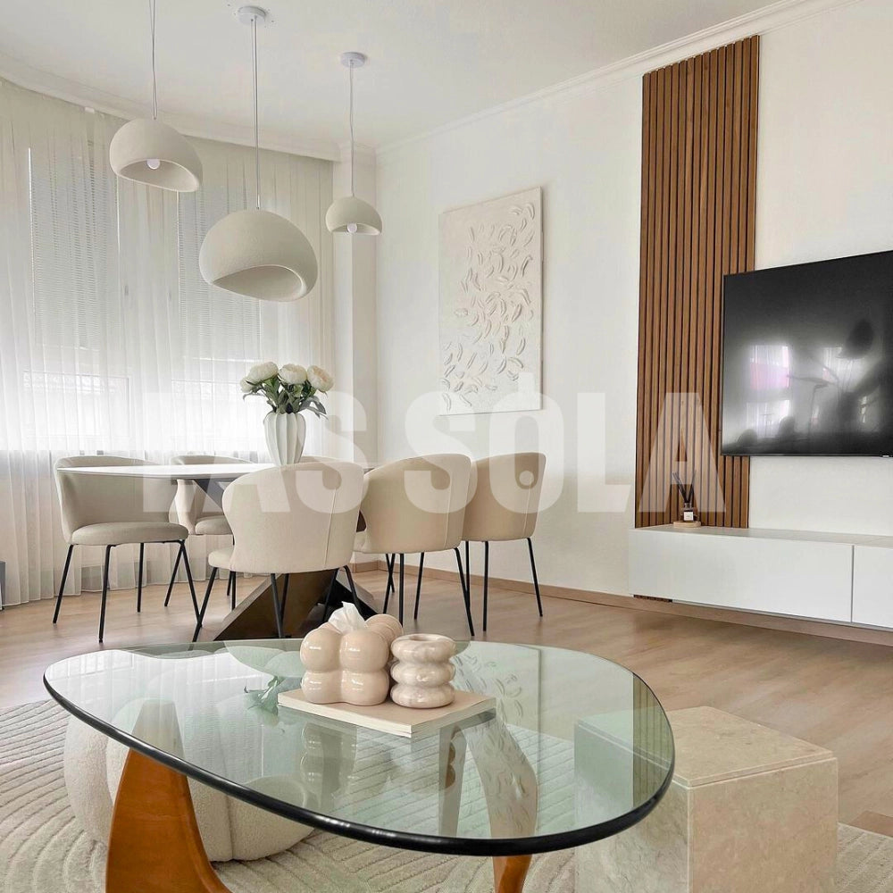 Modern minimalist white dome pendant light hanging above a stylishly arranged living room with wooden flooring, featuring a table and chairs as part of the elegant decor.