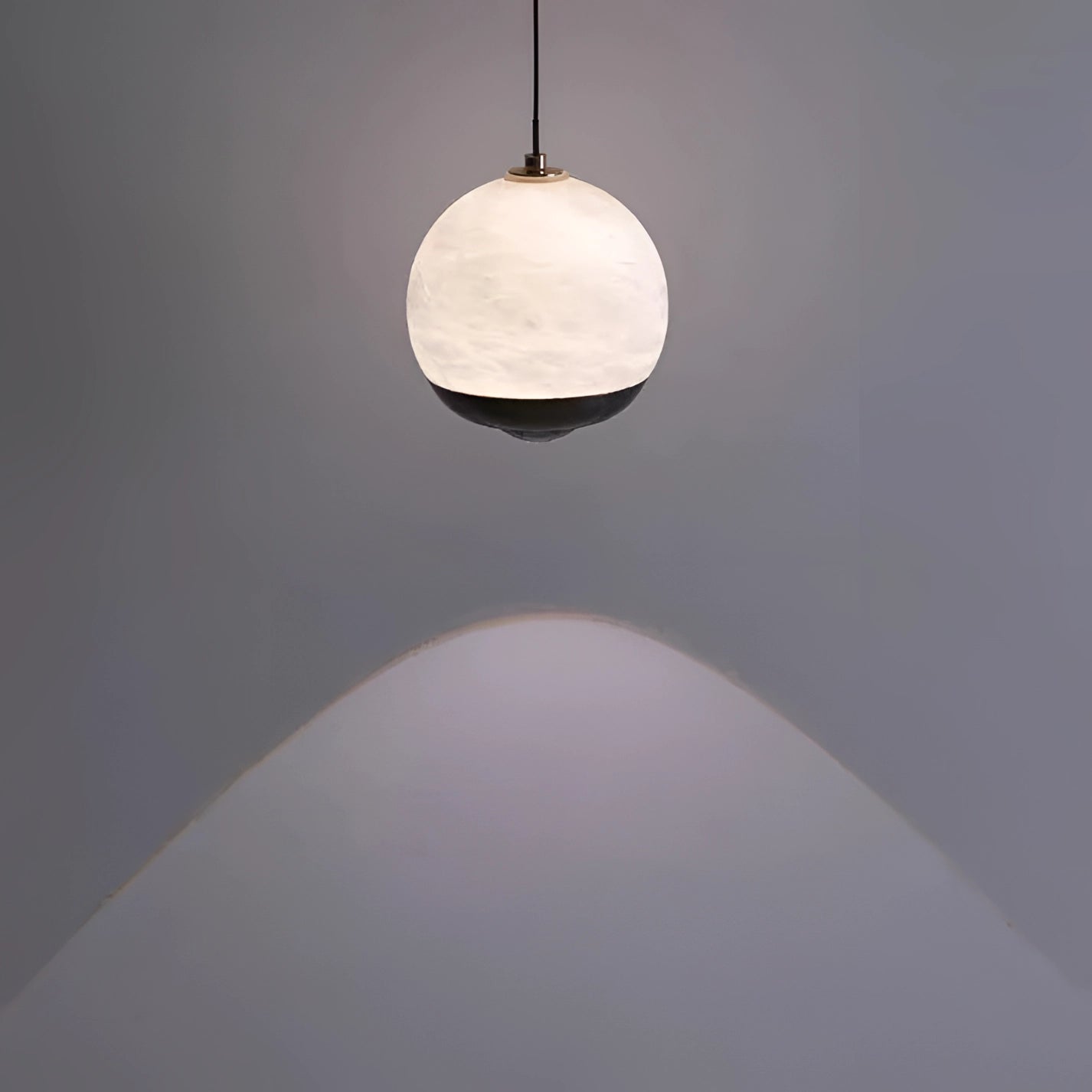 Modern minimalist black spherical pendant light hanging from the ceiling, with a sleek and elegant design suitable for bedroom decor.
