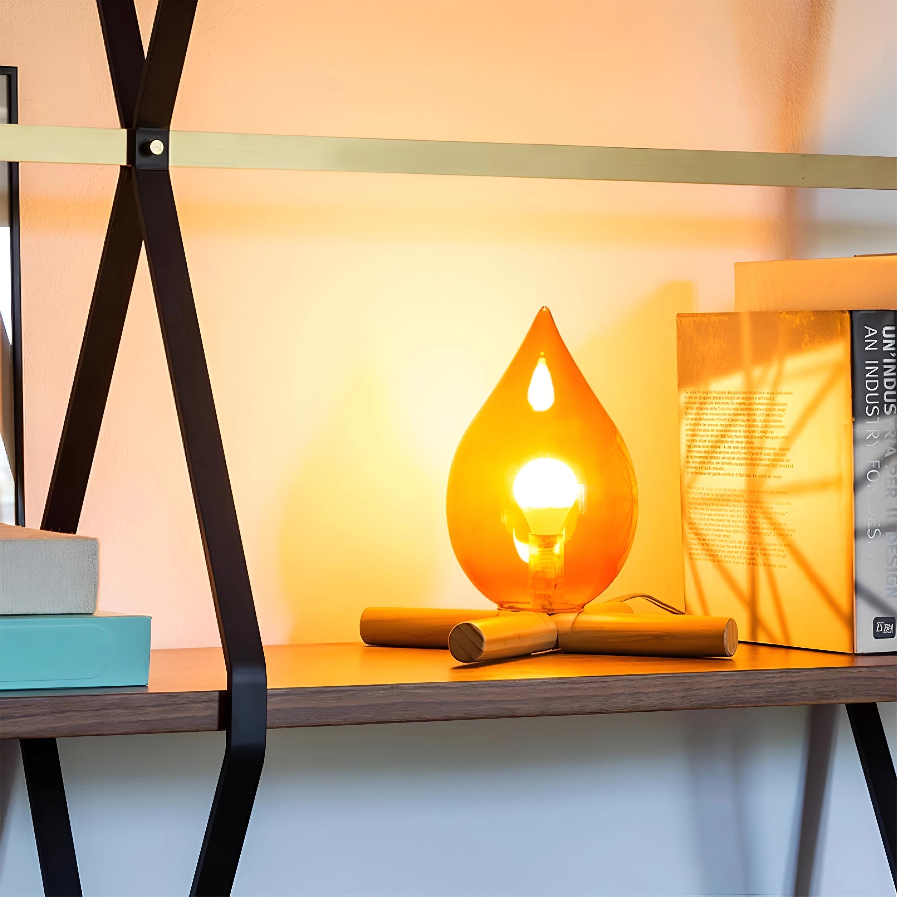 Modern orange glass flame lamp with an artistic design, featuring a vibrant combination of amber, orange, and red hues. The lamp emits a warm glow, enhancing its aesthetic appeal. It is supported by a wooden base and designed with angular lines that suggest a triangular form.