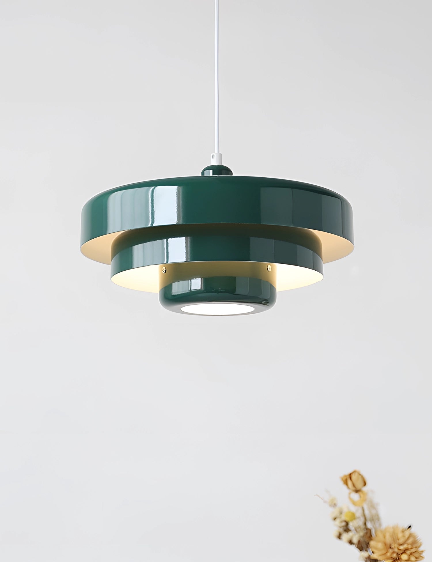Modern orange pendant light with a cylindrical shape, hanging from the ceiling, set against a contemporary indoor background.