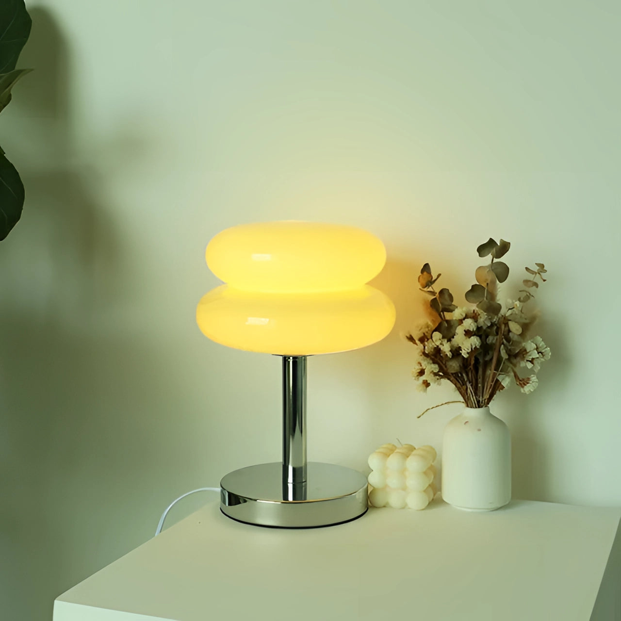 Modern orange spiral table lamp with a stylish base, featuring a yellow hue and USB connectivity, placed on a coffee table.