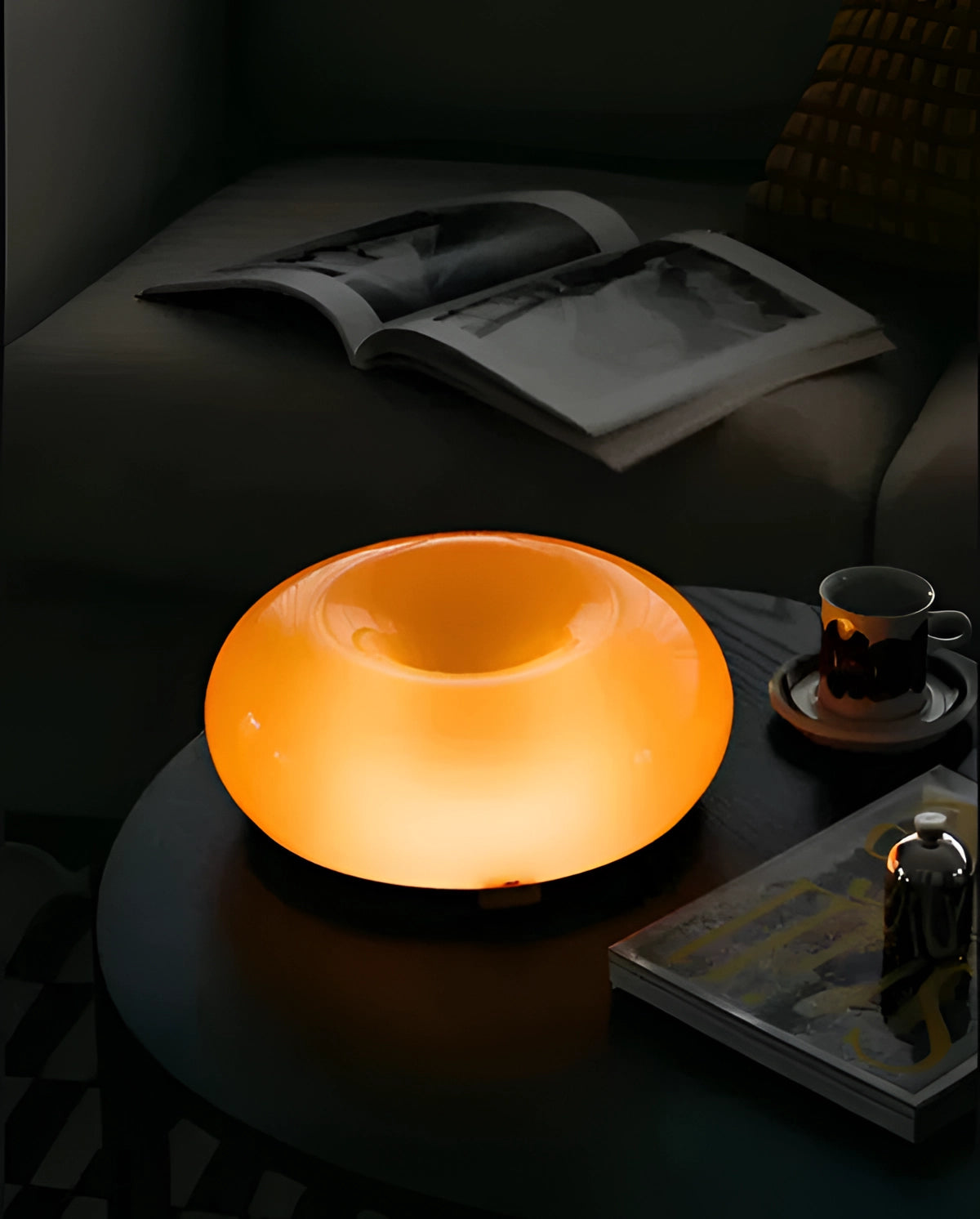 Modern orange wall sconce with a circular contemporary design, mounted on a wall, enhancing the interior decor with its vibrant hue and artistic appeal.