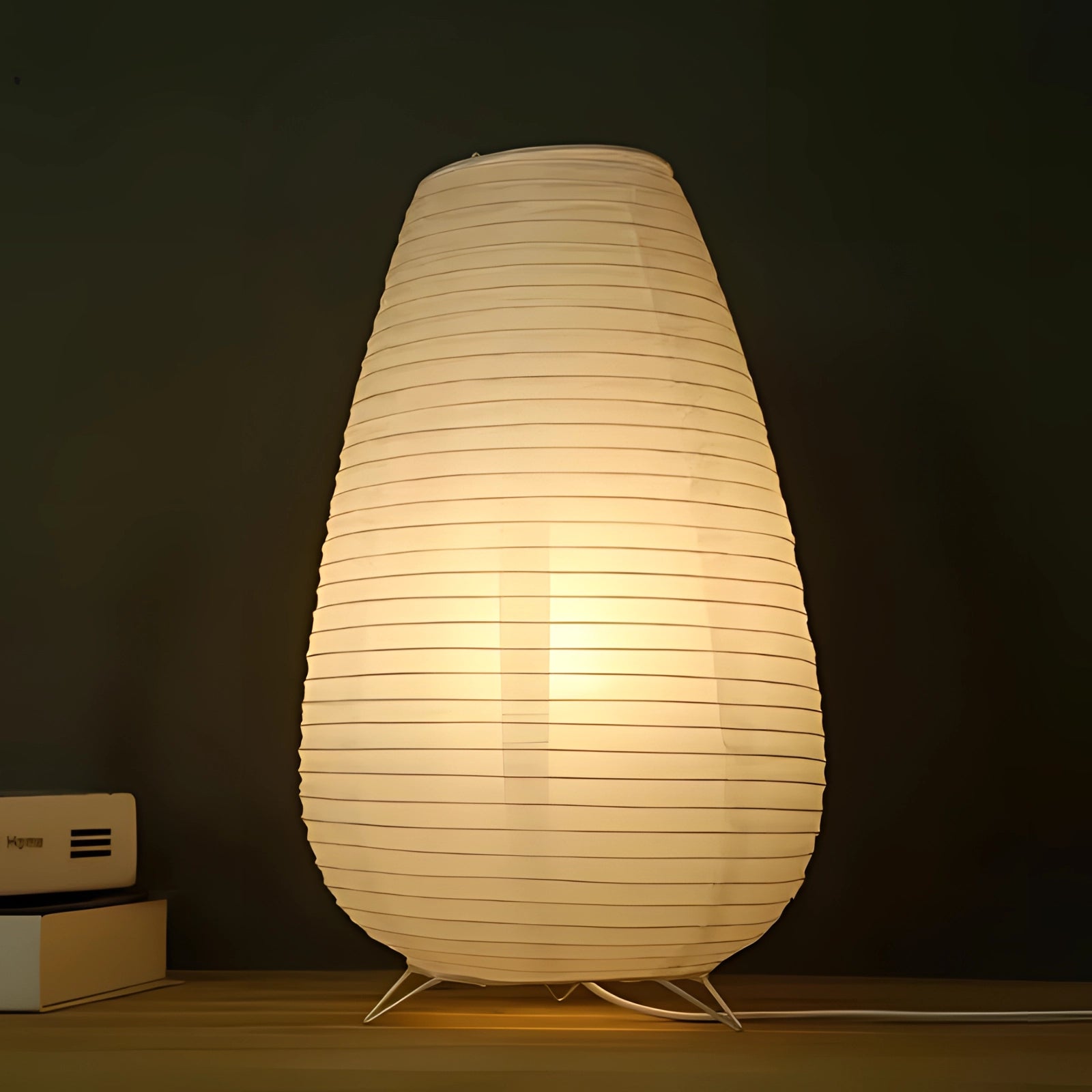 Modern oval paper floor lamp with a wooden base and LED lighting, featuring a lantern-style lampshade that emits a warm tint, suitable for adding artistic ambiance to any room.