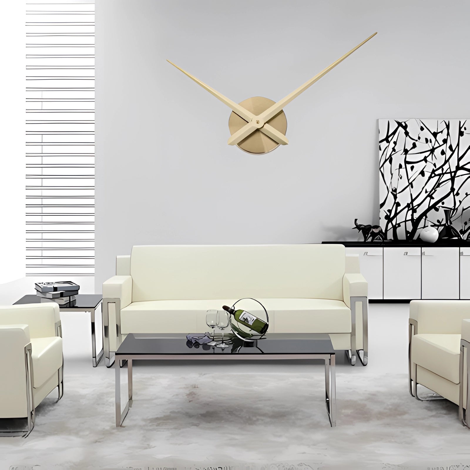 Modern oversized black wall clock with gold accents displayed in a minimalist living room with a grey couch and wooden flooring.