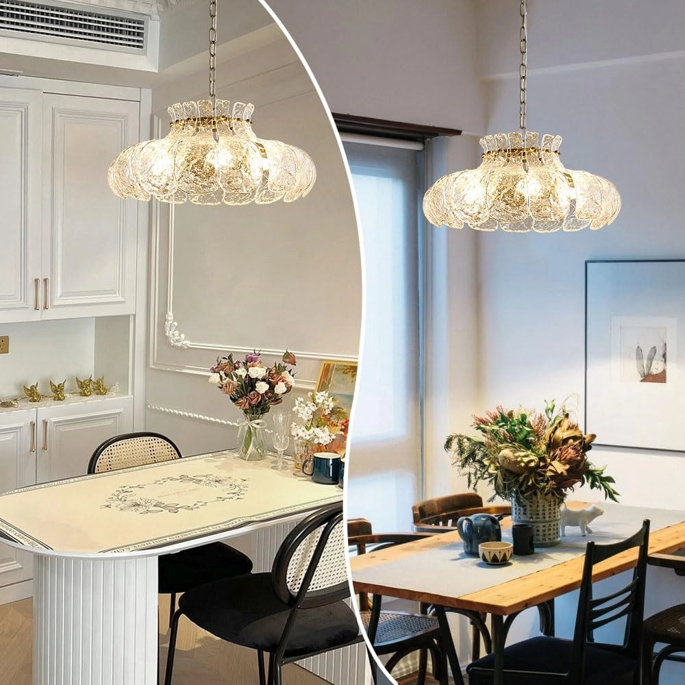 Modern pear glass chandelier with gold chain hanging from the ceiling, illuminating a stylishly designed interior space featuring a wooden table, white walls, and a potted plant, showcasing luxury lighting and elegant interior design.