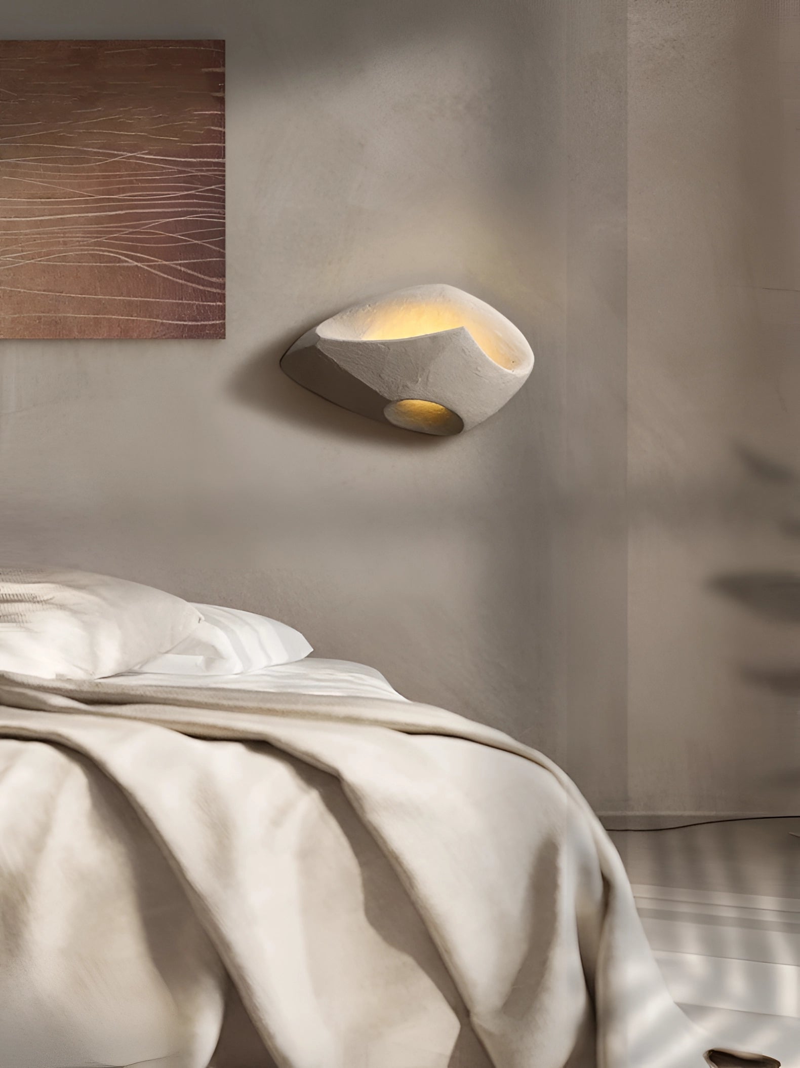Modern pebble wall lamps with a stone look, mounted indoors against a wooden wall, providing ambient lighting with a natural and artistic design.