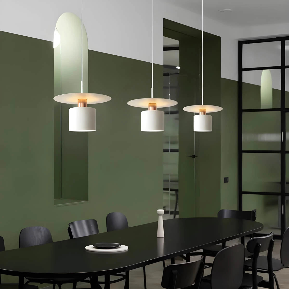 Modern Scandinavian minimalist pendant light hanging from the ceiling, illuminating a stylish interior space with wooden furniture, including a table and chair.