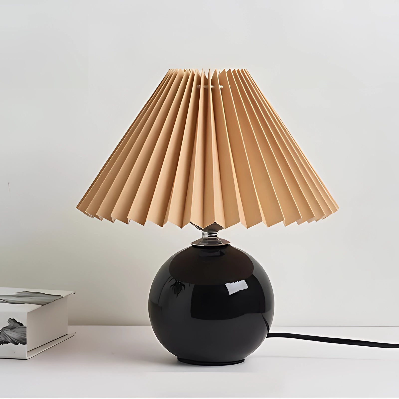 
A modern pink ceramic lamp with a pleated shade, featuring a Scandinavian design. The lamp has a contrasting brown and black base, complementing its artistic and contemporary style.