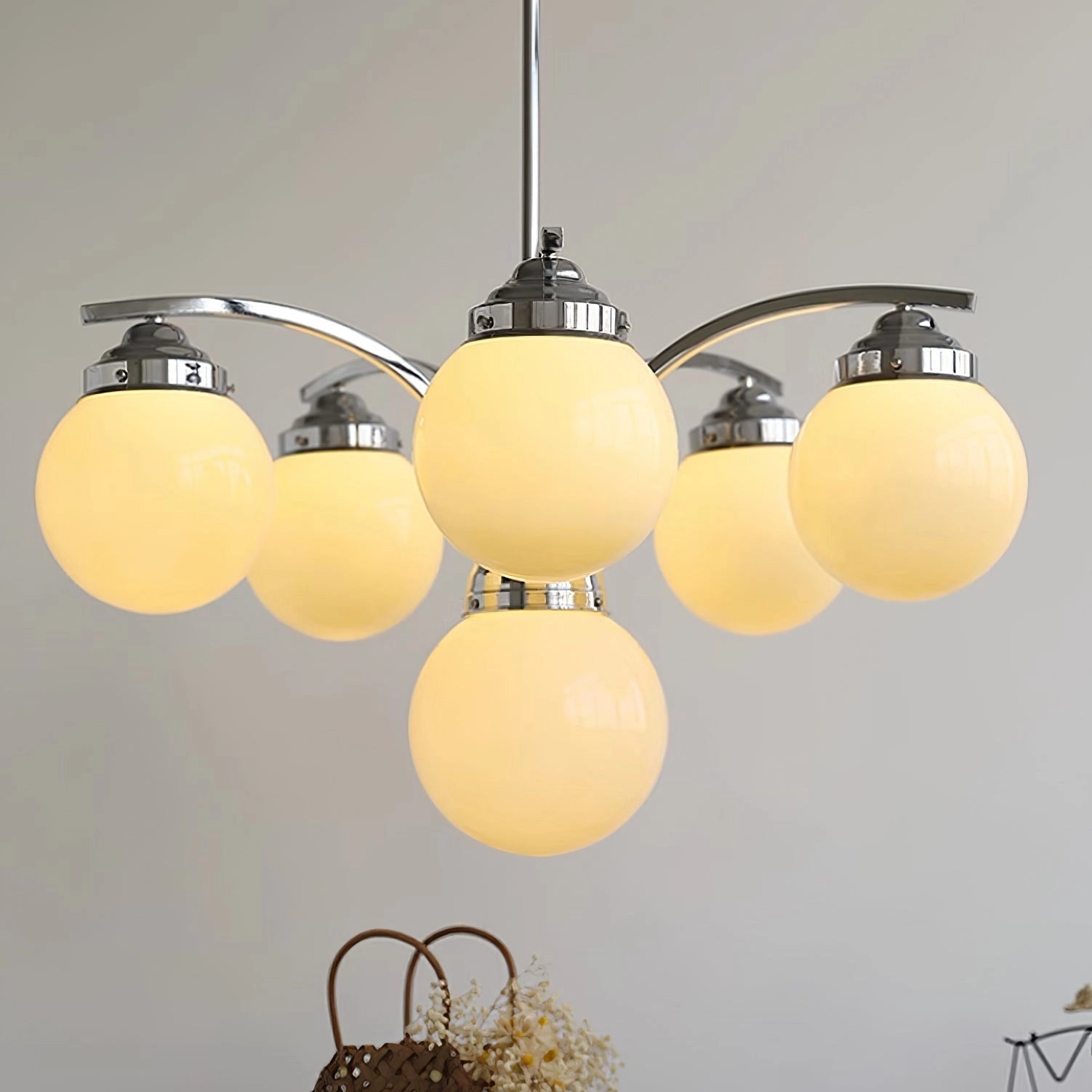 Modern pink glass chandelier with elegant minimalist design, featuring circular shapes and soft tints, illuminating a ceiling space.