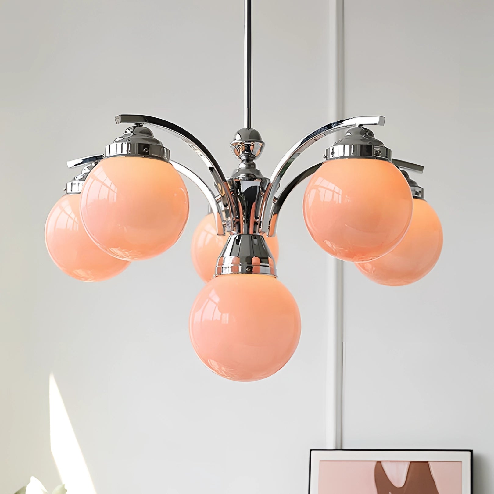 Elegant minimalist modern pink glass chandelier hanging from ceiling, featuring symmetrical design and soft pink tints.