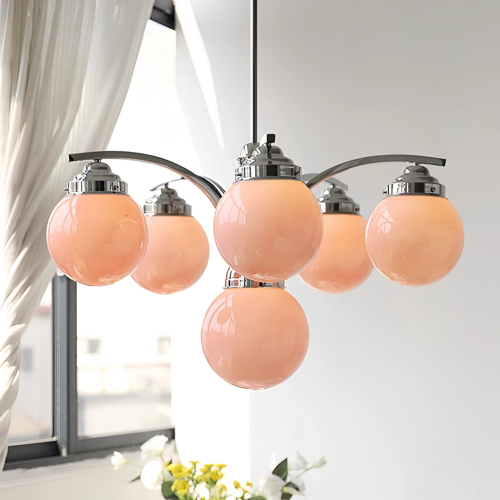 Modern pink glass chandelier with elegant minimalist design, hanging from the ceiling, illuminating the room with a soft light.