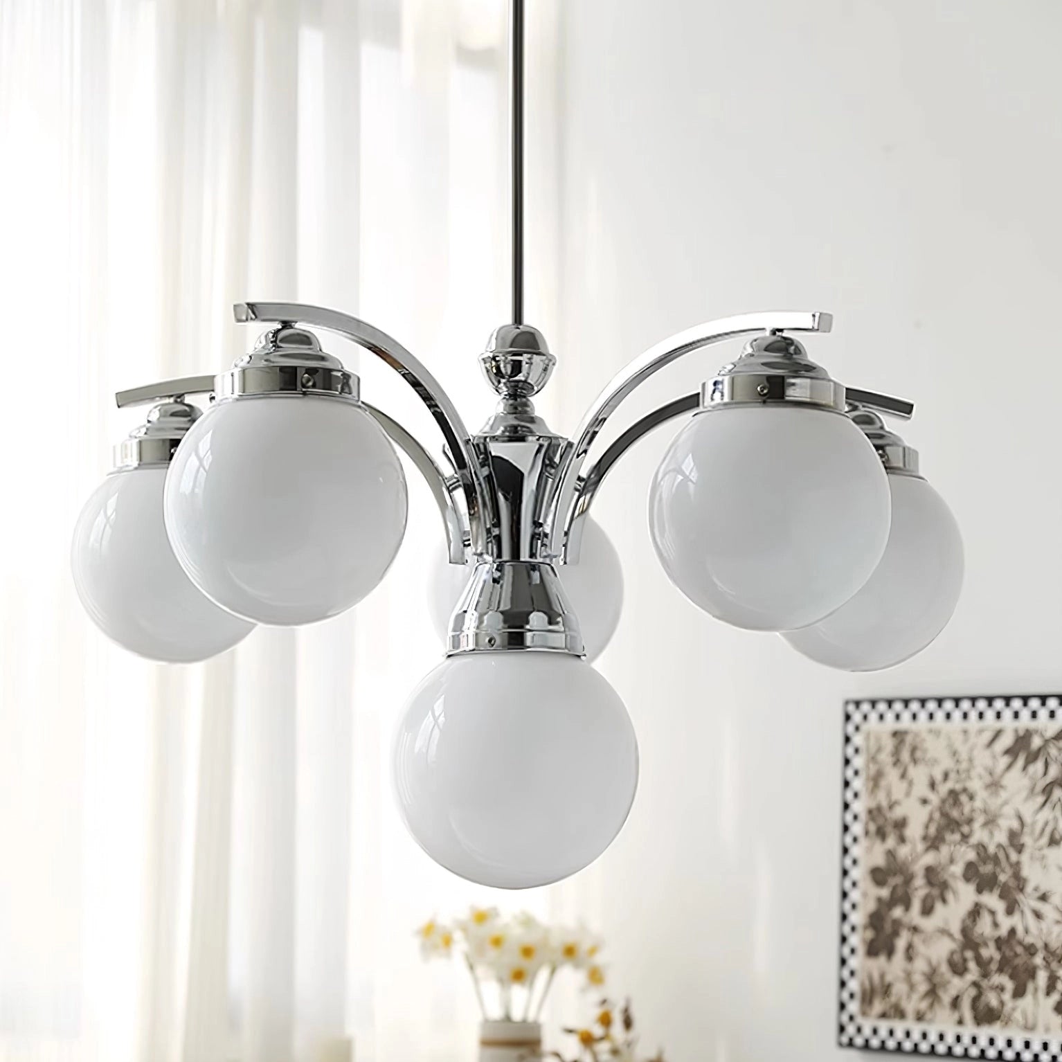 Modern pink glass chandelier with elegant minimalist design, hanging from the ceiling, featuring circular metal ornaments and symmetrical decoration.