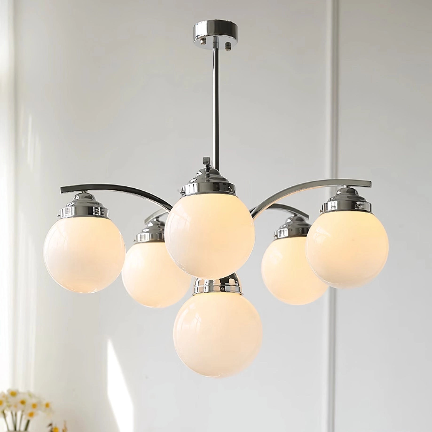 Elegant minimalist modern pink glass chandelier with circular ceiling fixture, providing a stylish lighting solution.