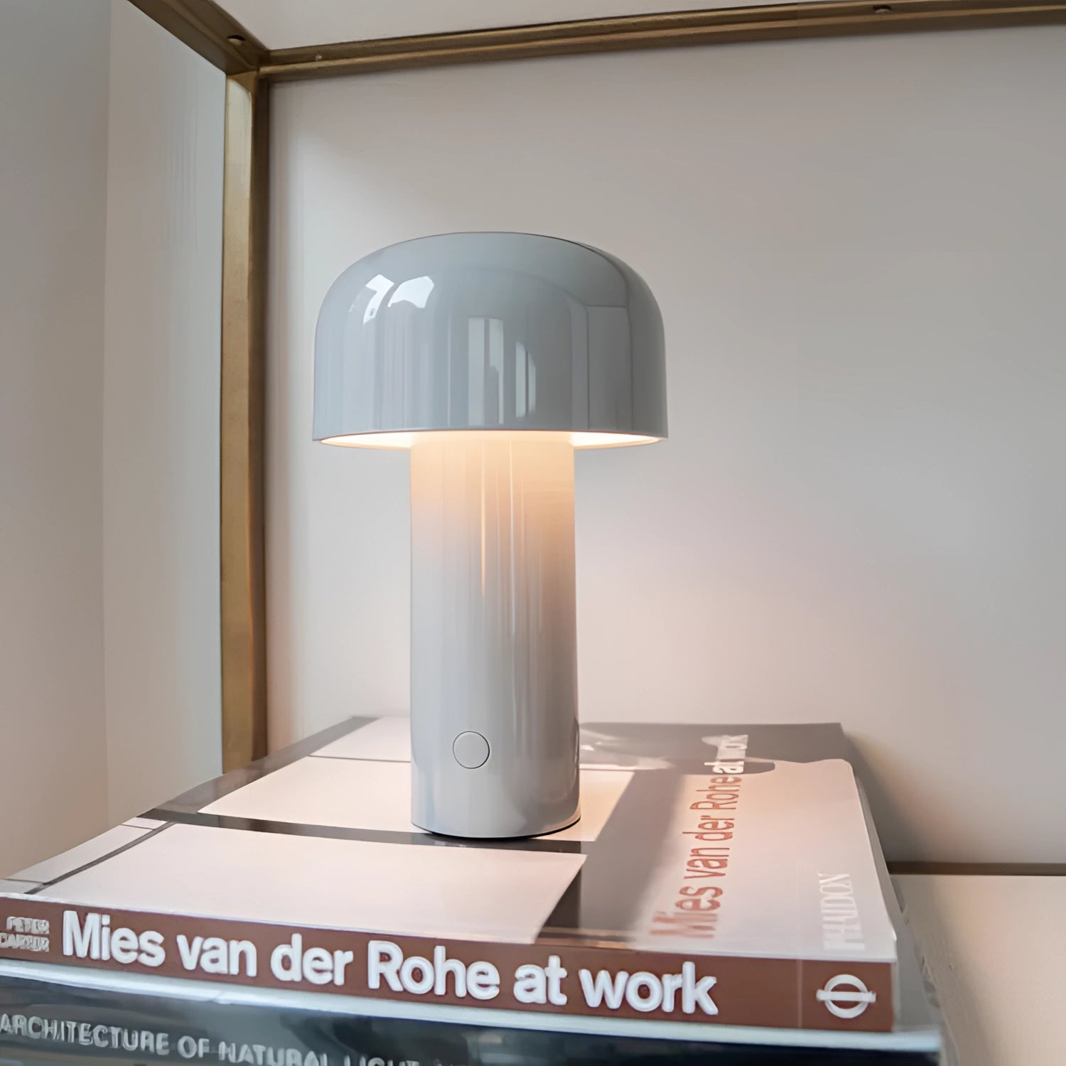 Portable wireless LED lamp with a sleek cylindrical design, featuring a touch control interface, placed on a wooden surface next to a potted plant.