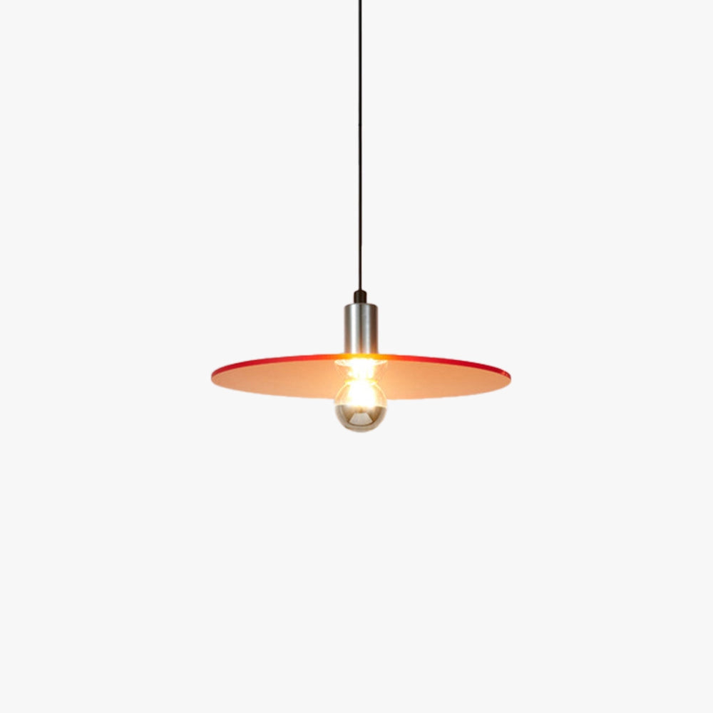 Modern red metallic pendant light with an industrial design, hanging from a ceiling. The light fixture is crafted from metal and features a sleek, contemporary style. The image also includes a wooden table with a small plant, adding a touch of natural decor to the setting.