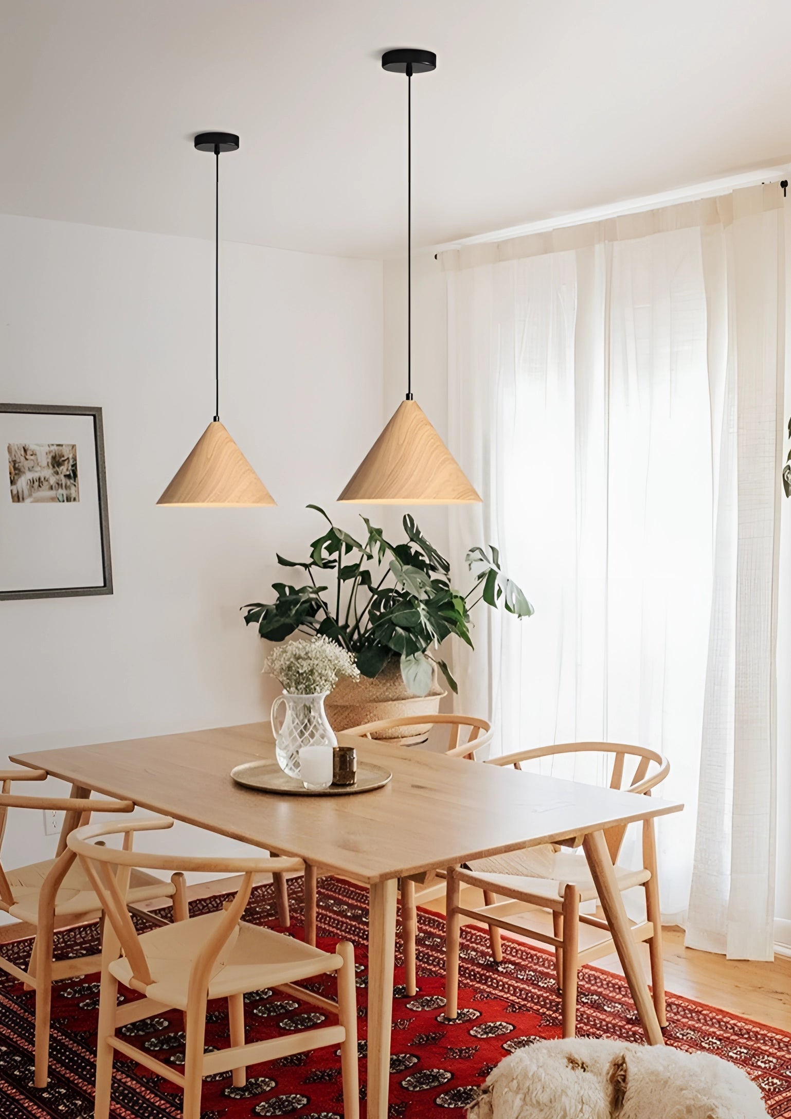 Modern Scandinavian eco-friendly triangle wooden pendant light hanging in a stylish interior setting with wooden elements, featuring a table with decorative items and plants, curtains, and a light-colored floor creating a warm and inviting ambiance.