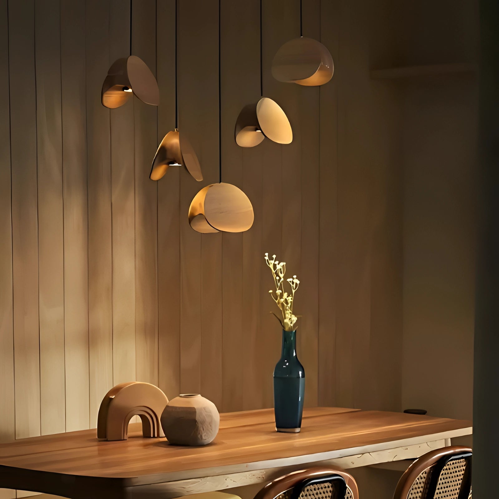 Modern Scandinavian geometric pendant light with wood accents, hanging above a stylish interior setting featuring a wooden table, decorative vases, and a well-lit room design.