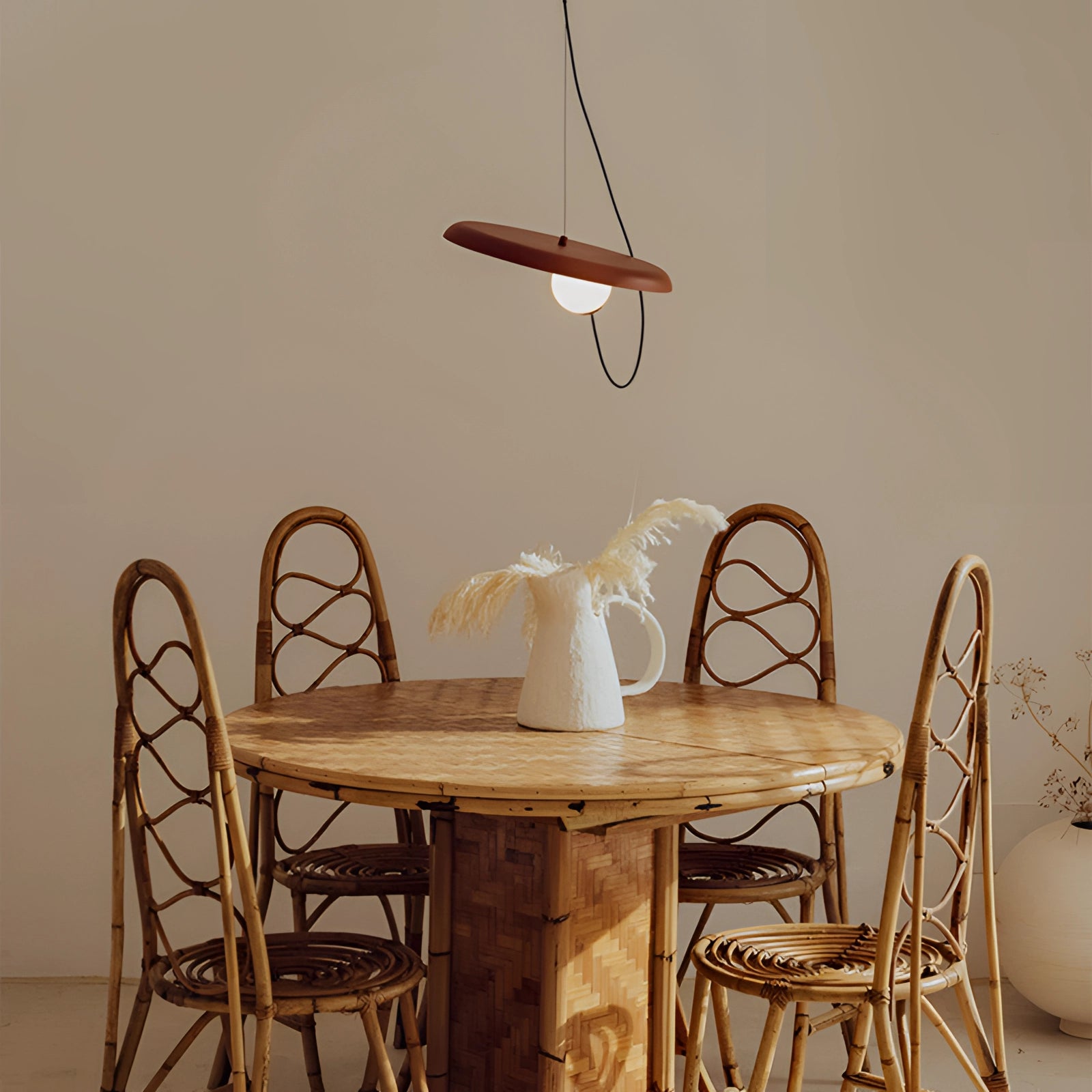 Modern Scandinavian pendant light with a minimalist design and wood accent, featuring a 9.8-inch copper finish, hanging above a wooden table and chairs.