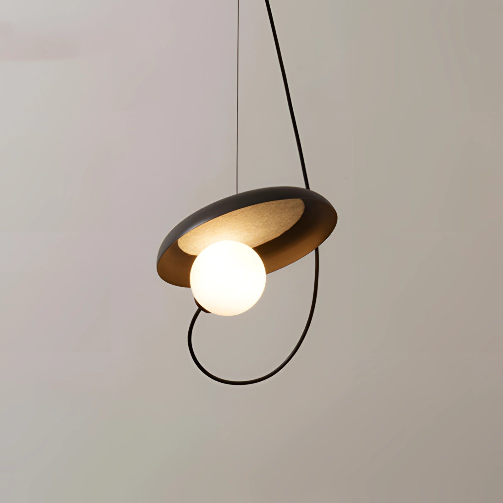 Modern Scandinavian pendant light featuring a minimalist design with a wooden accent, hanging from the ceiling, emitting warm light.