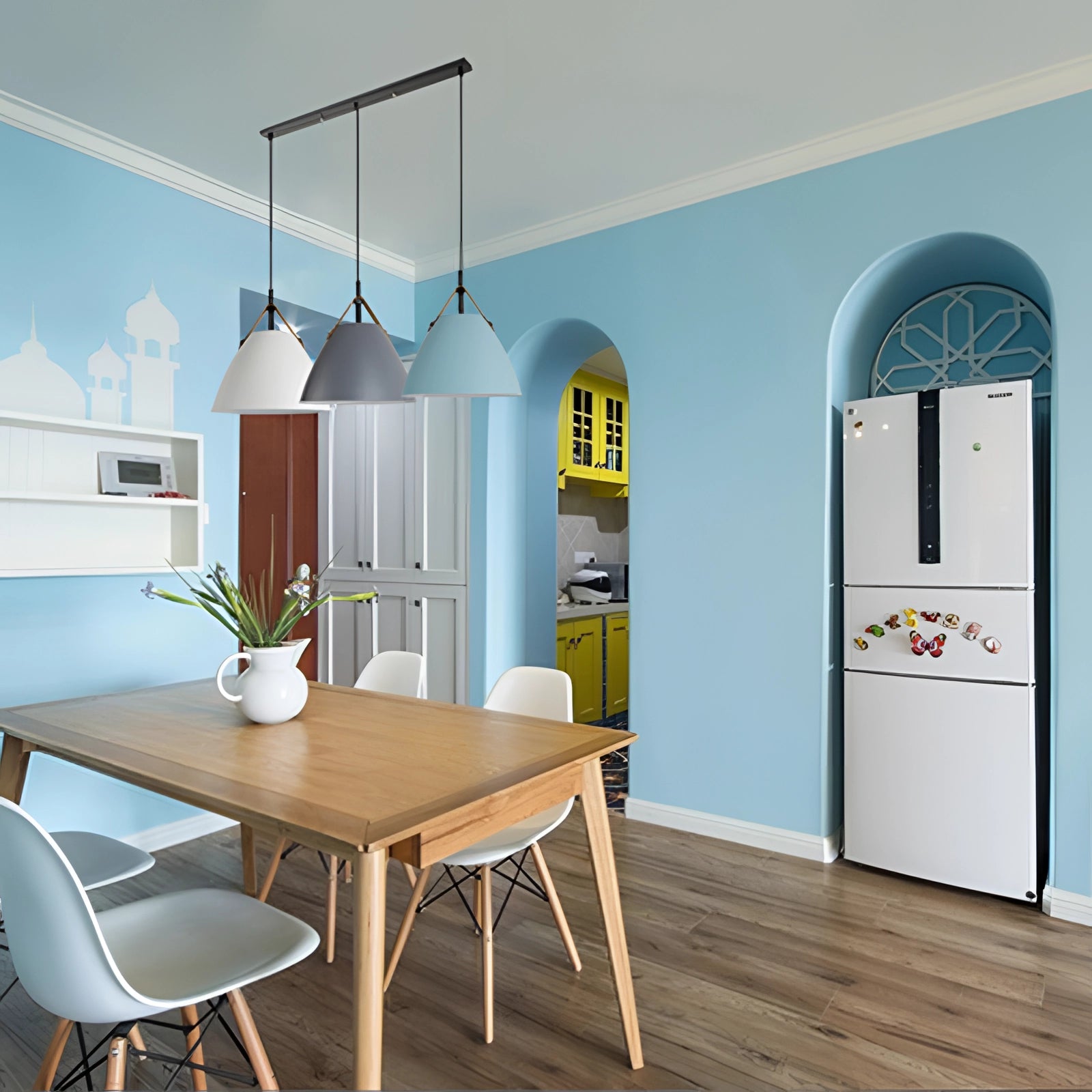 Modern Scandinavian pendant lights with a rectangular design and three adjustable heads in black and white finish, hanging above a stylish interior setting with wooden furniture, a table with a plant, and chairs, emphasizing a contemporary and minimalist aesthetic.