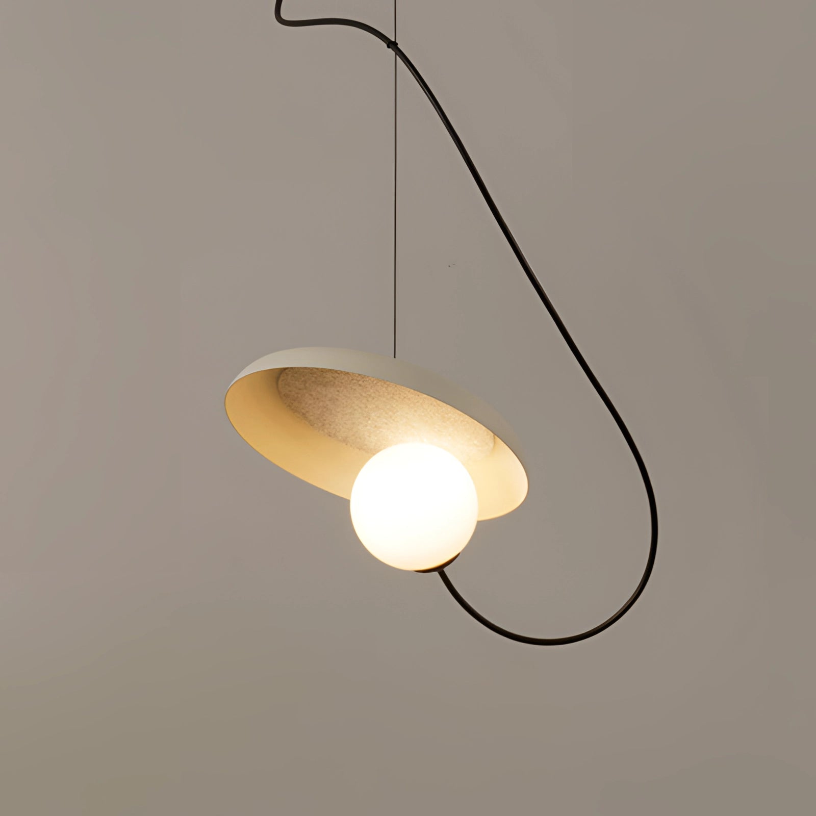 Modern Scandinavian pendant light with a minimalist wood accent design, featuring a circular metal lampshade suspended from the ceiling, illuminated by a light bulb.