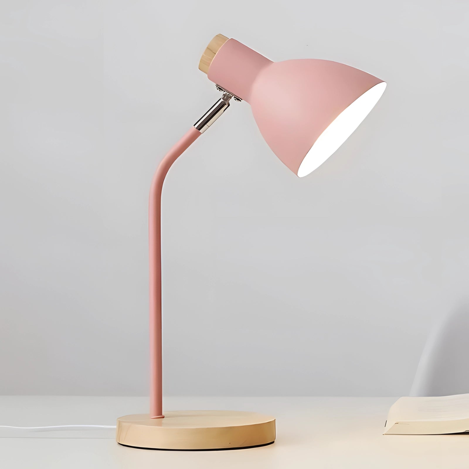 Modern Scandinavian pink desk lamp with adjustable features and a wooden base, featuring a sleek metal design and soft magenta hue, ideal for adding stylish lighting to any workspace or room.