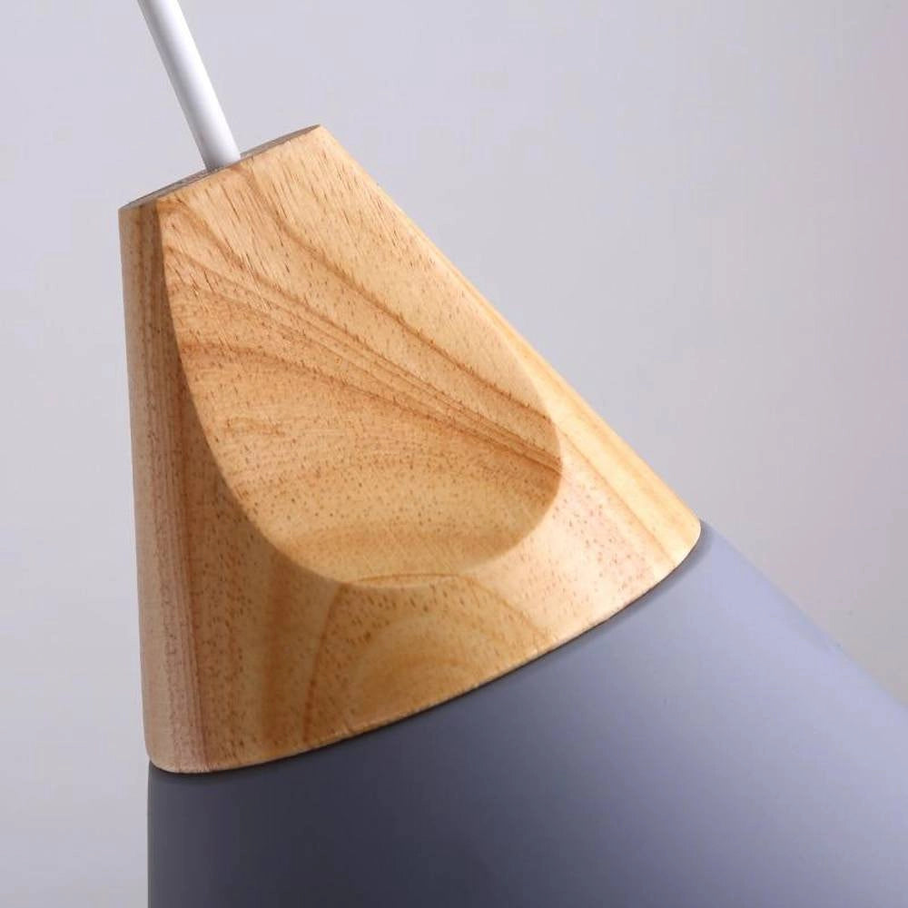 Modern Scandinavian wood pendant lights in dual-tone gray and yellow, adjustable height, hanging above a wooden interior with beige and peach tones, featuring plywood and hardwood elements.