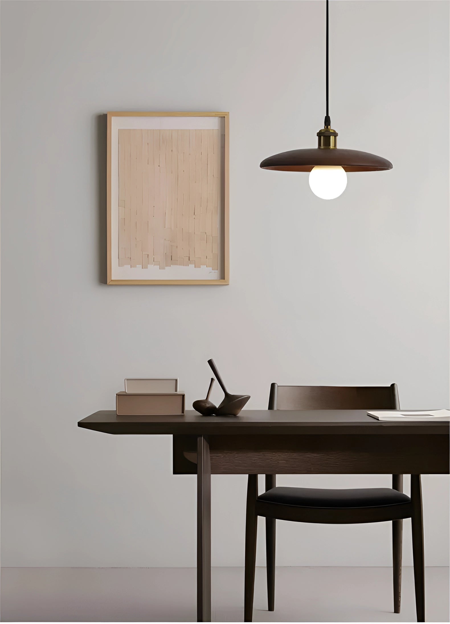 Modern Scandinavian wooden pendant light with eco-friendly design and brass accents, hanging above a grey writing desk with a plant.