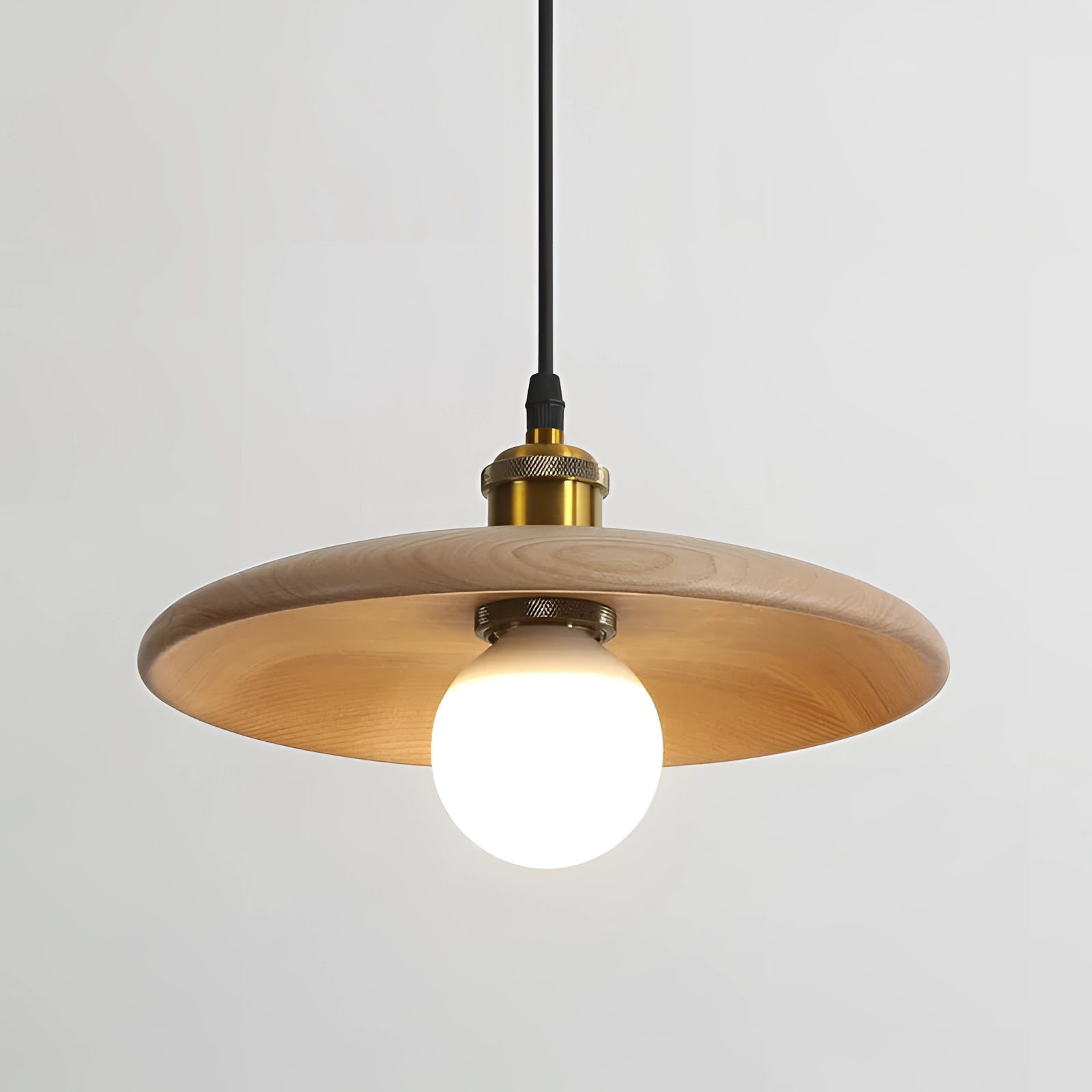 Modern Scandinavian Wooden Pendant Light made of oak wood with brass accents, featuring a circular lampshade and light bulb, hanging over a table.