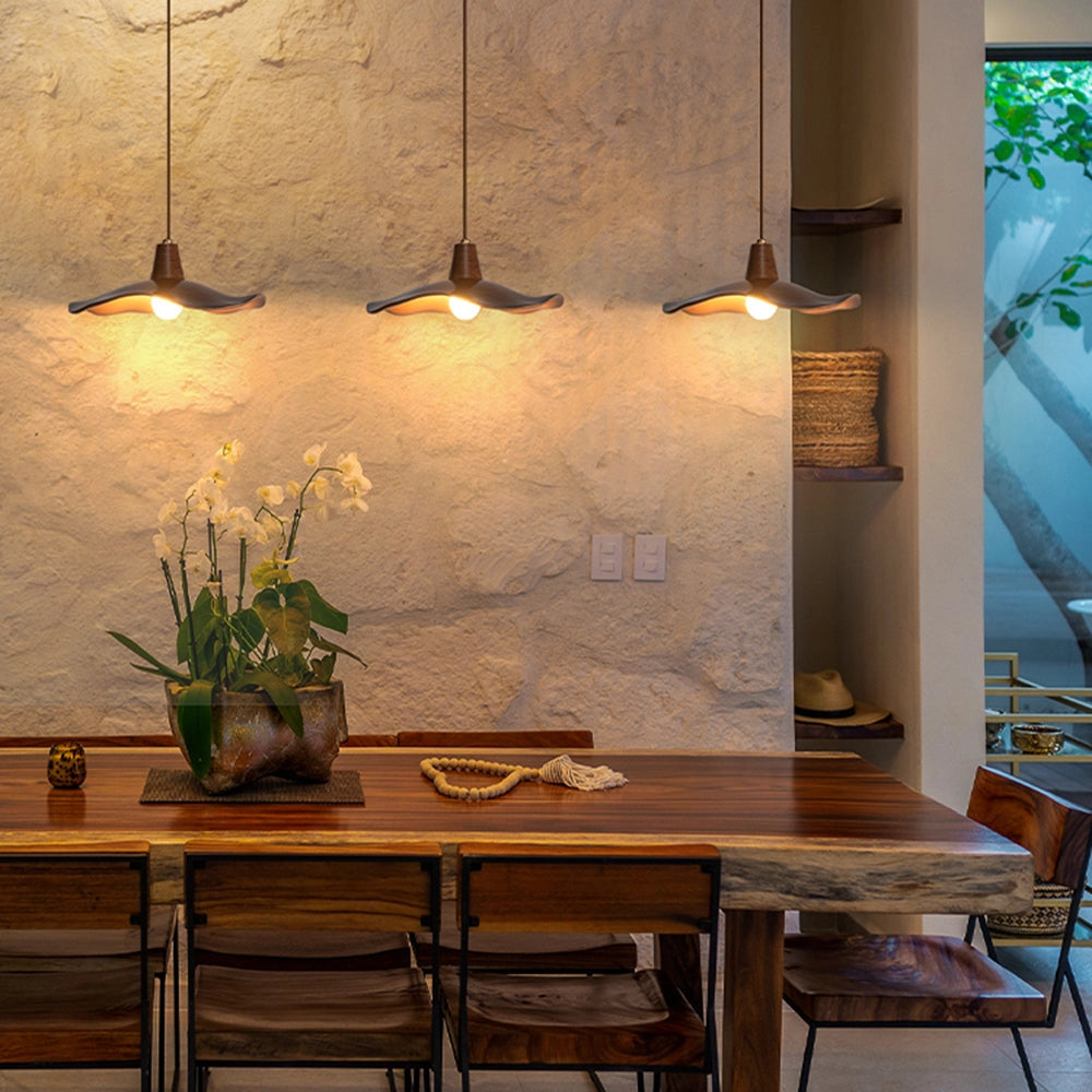 Modern sculptural wood pendant light with a handcrafted organic design, featuring a 14.9-inch size and 3-light configuration, elegantly suspended above a dining table with houseplants and minimalist interior decor.
