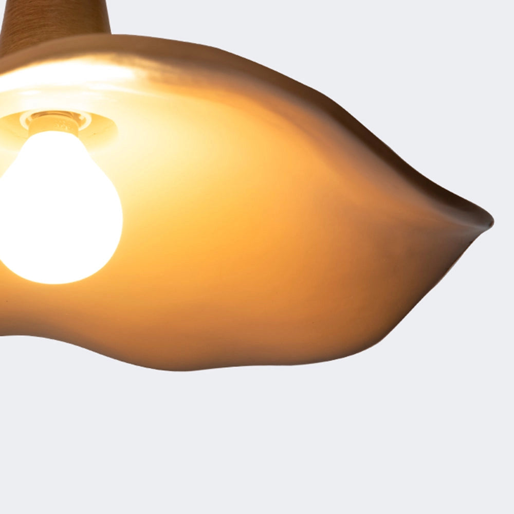 A handcrafted organic design pendant light featuring a sculptural wood element with amber tints, showcasing a modern aesthetic. The lamp includes a ceiling fixture and a visible light bulb, combining wood and metal materials for a contemporary look.