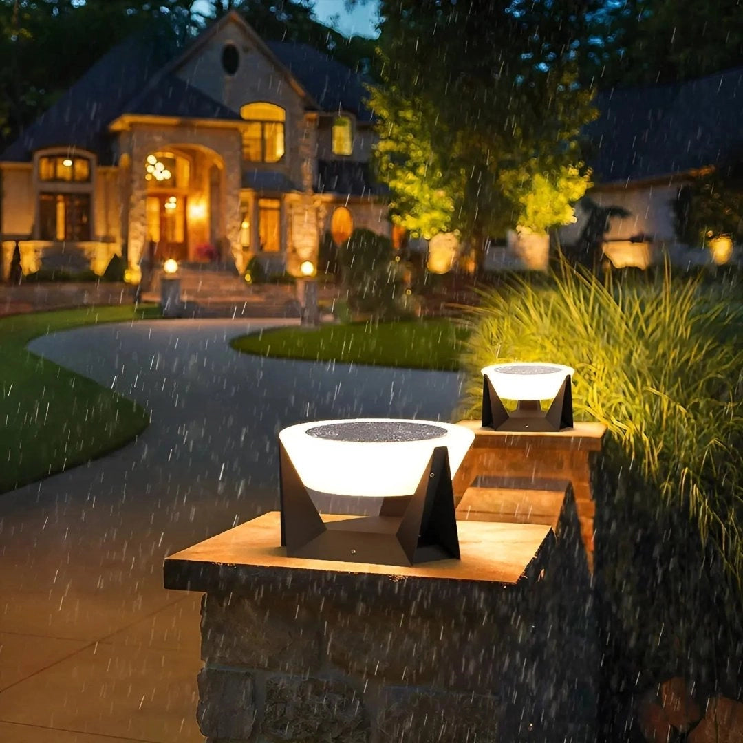Modern solar torch lights illuminating a lush garden landscape with surrounding trees and grass, adjacent to a house with visible windows and a clear sky overhead.